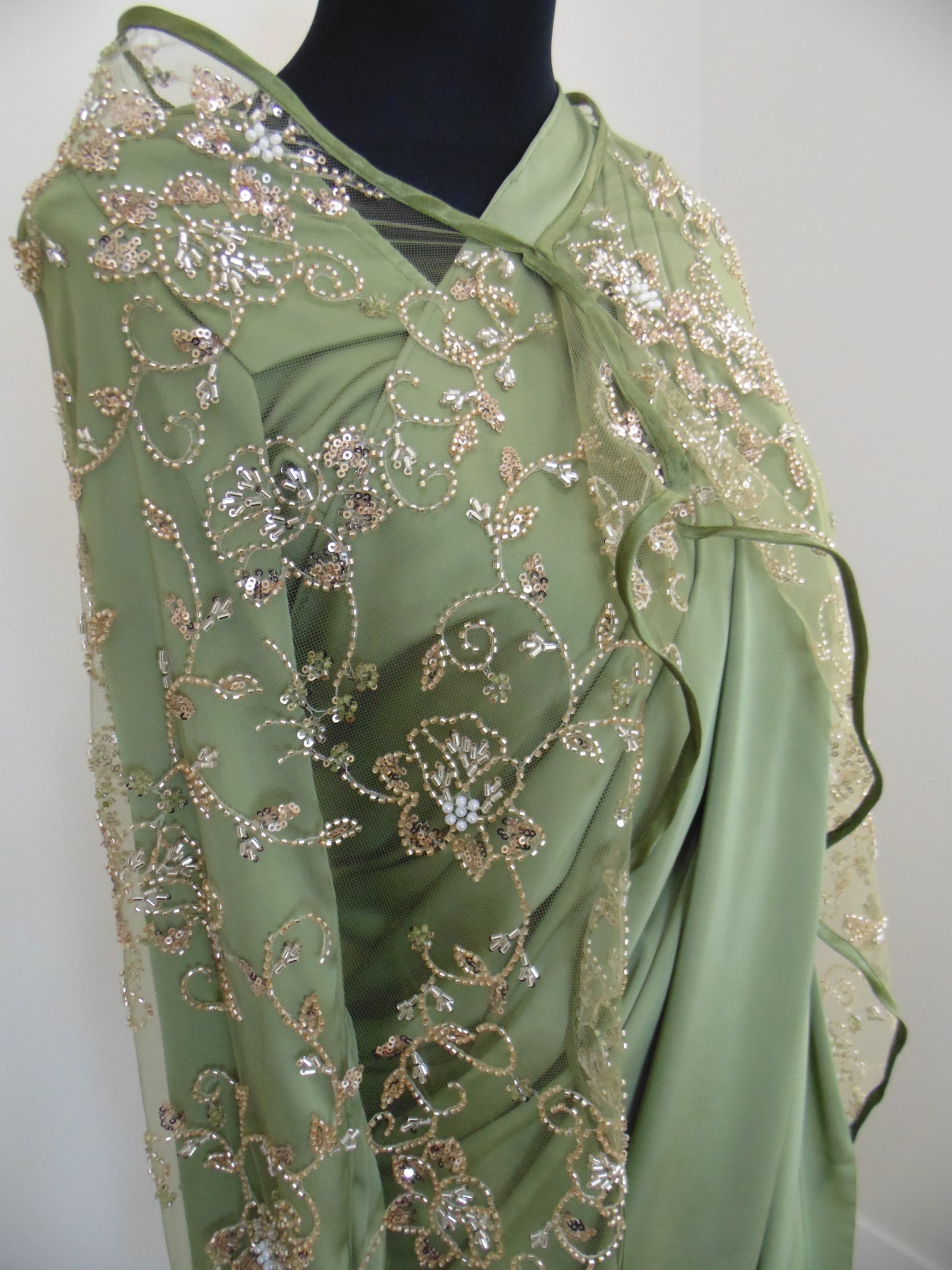 Green embroidered saree on a white background