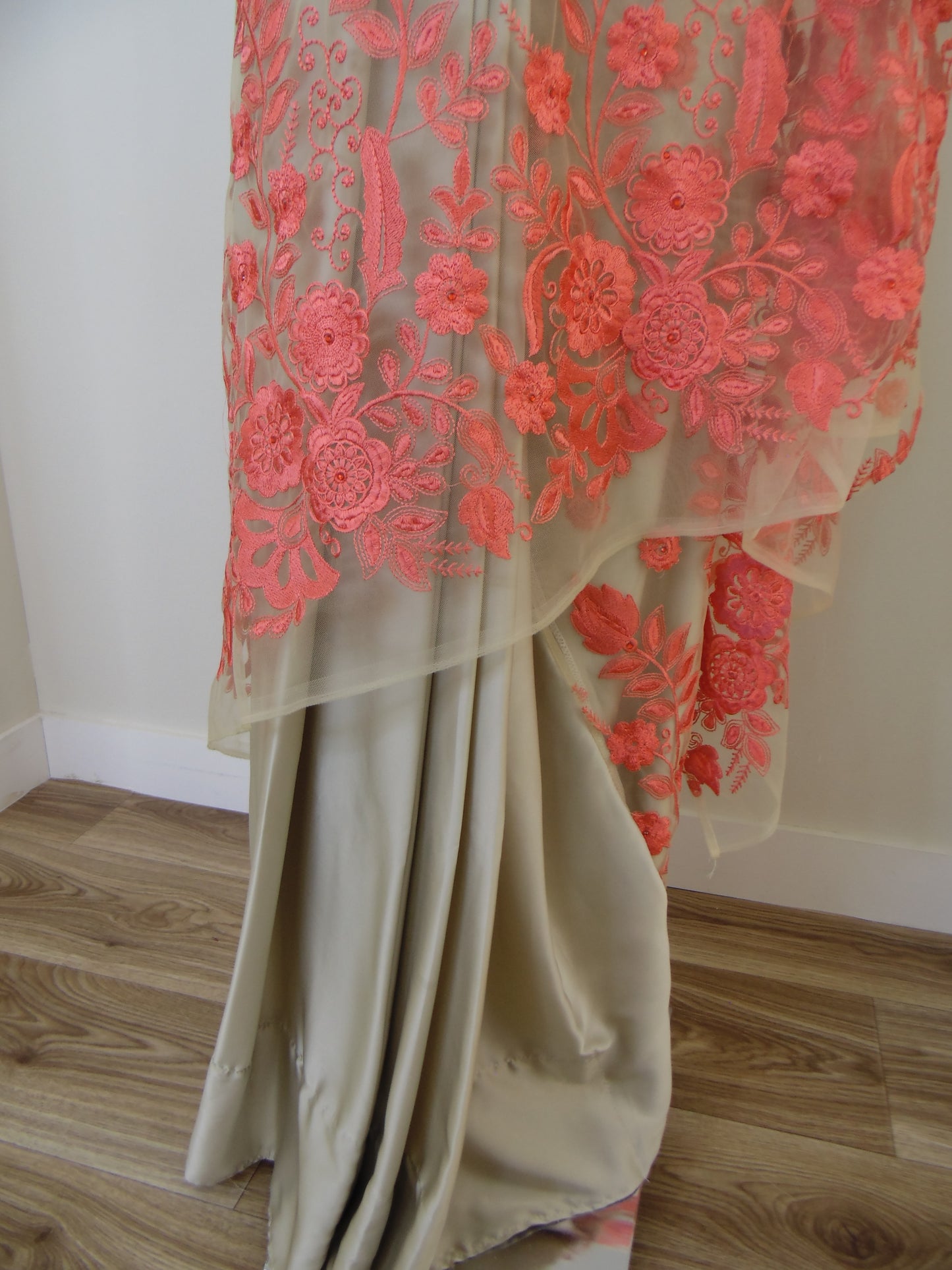 Beige fabric with Orange floral embroidery on a wooden surface