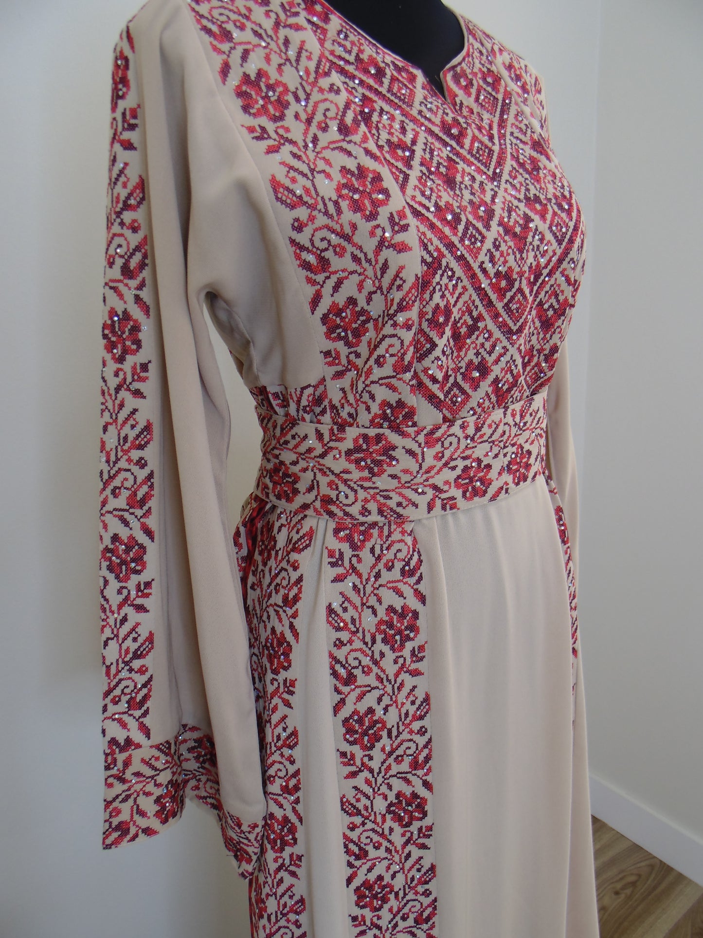 Traditional dress with red and white pattern on a white surface