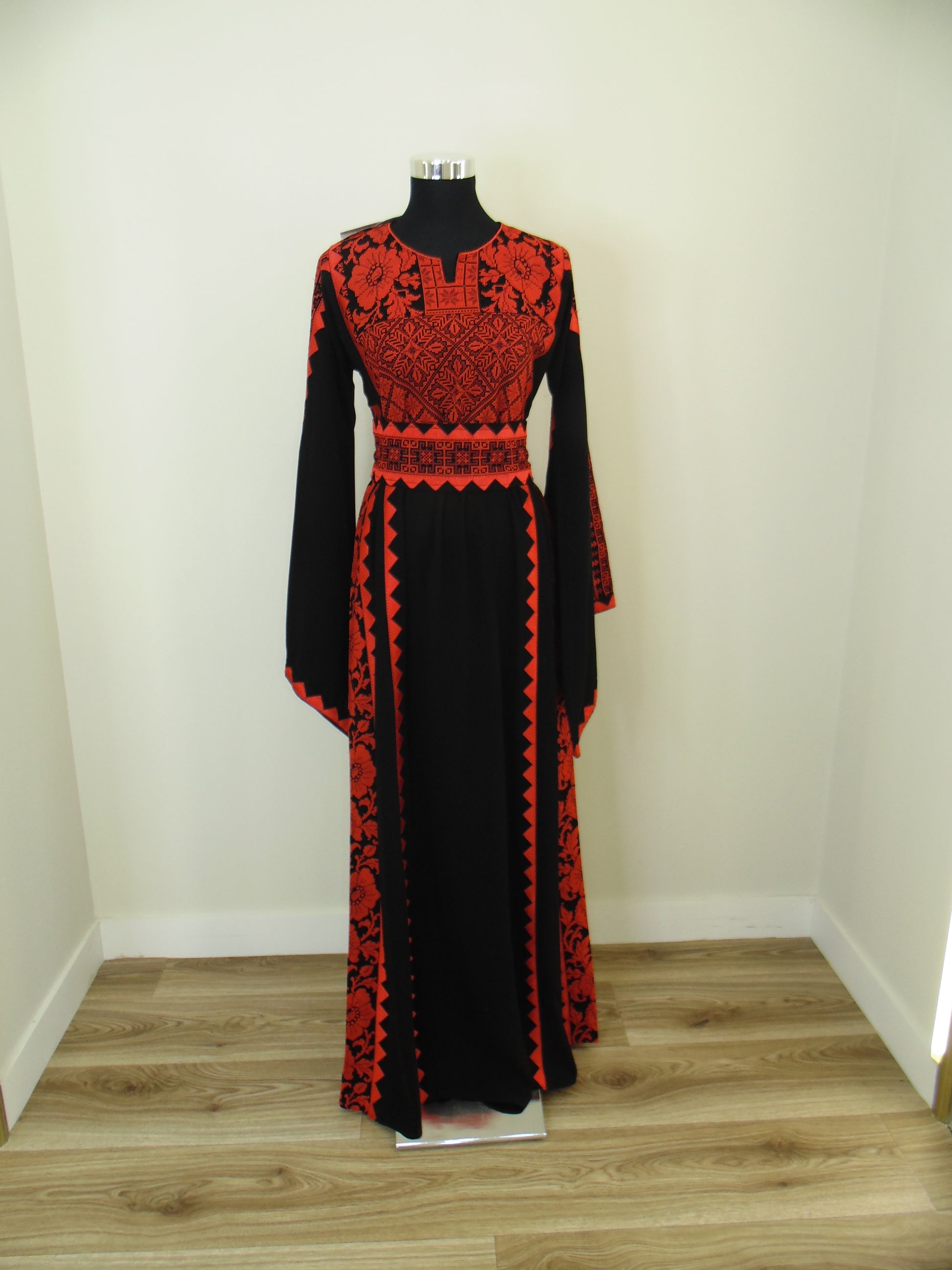 Red and black patterned garment on a mannequin in a store setting
