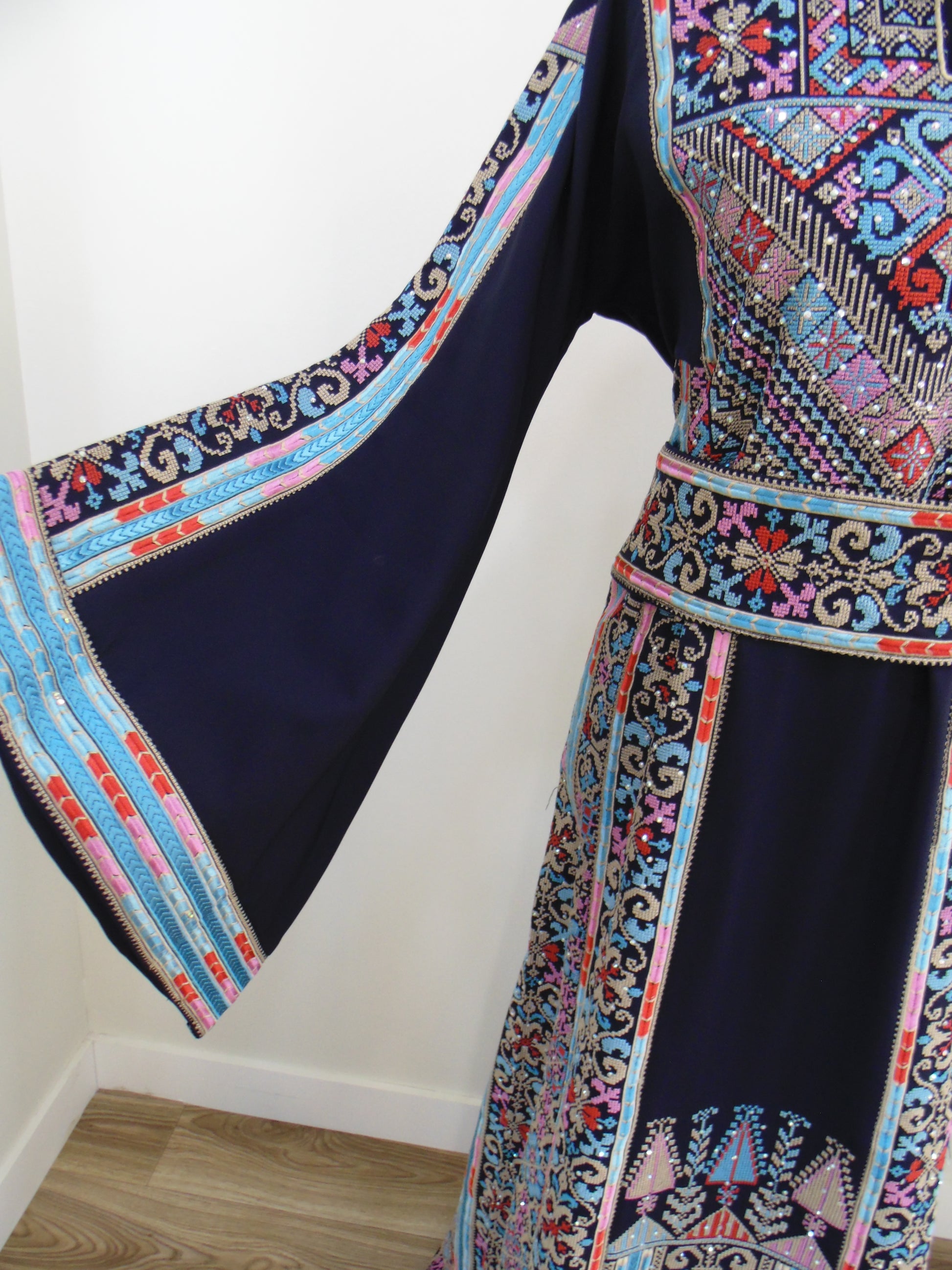 Traditional embroidered fabric with colorful patterns on a white background