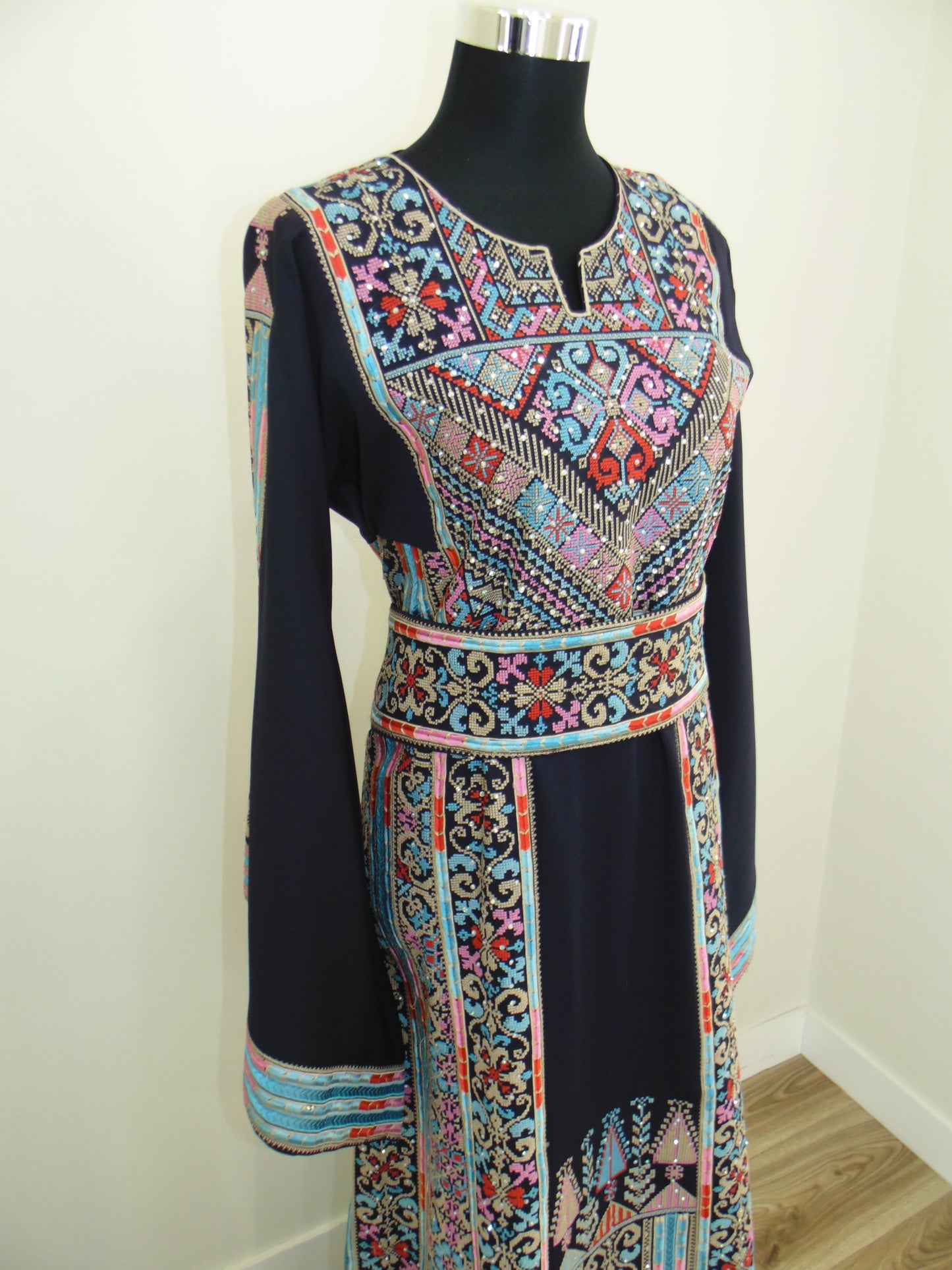 Colorful patterned thobe on a white surface