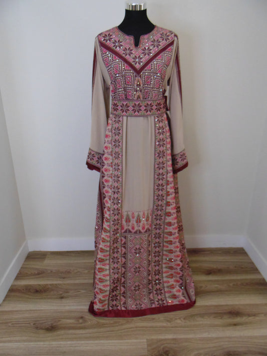 Traditional embroidered Palestinian Thobe on a mannequin against a white wall.