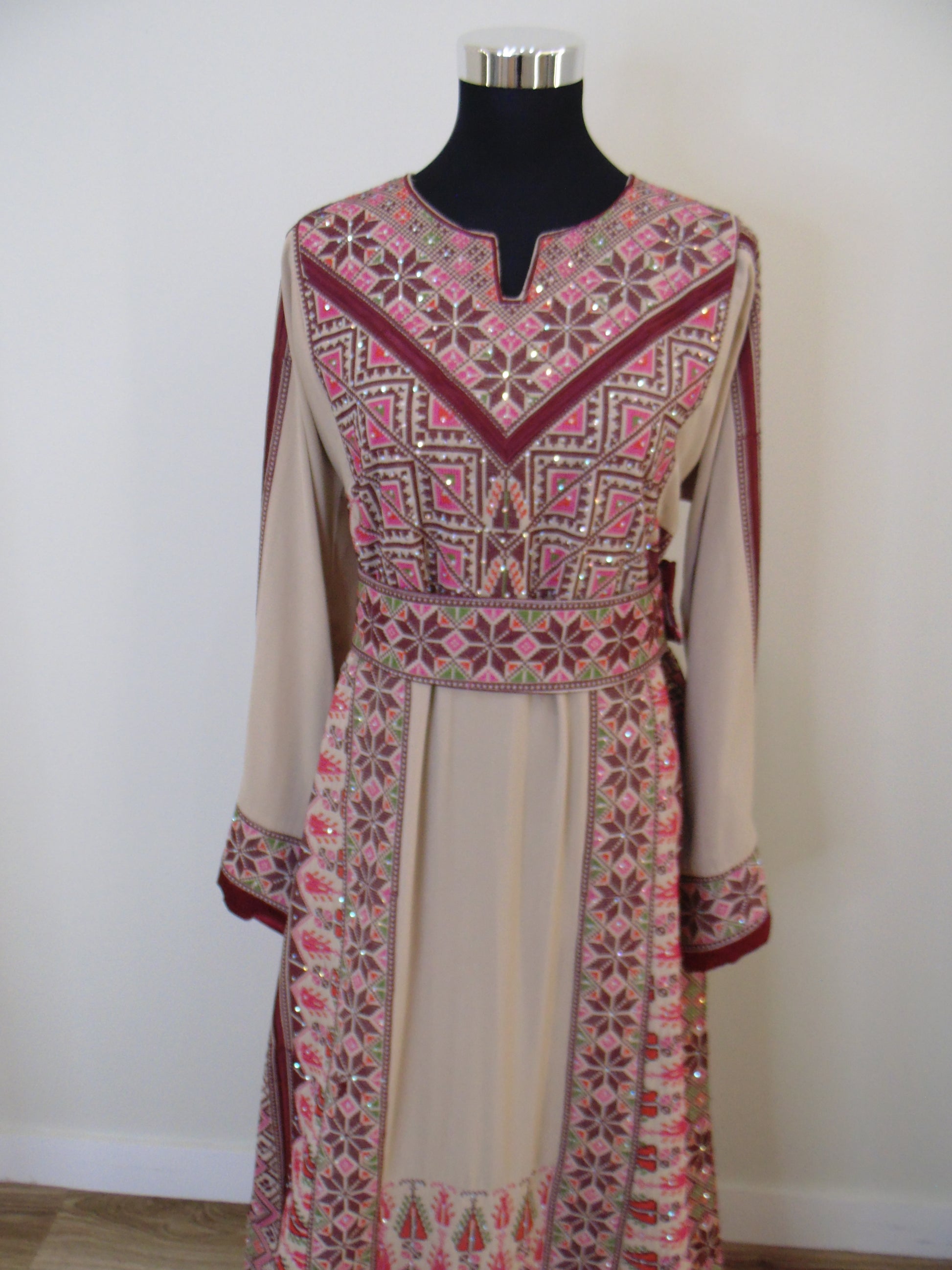 Traditional embroidered garment on a mannequin against a white background