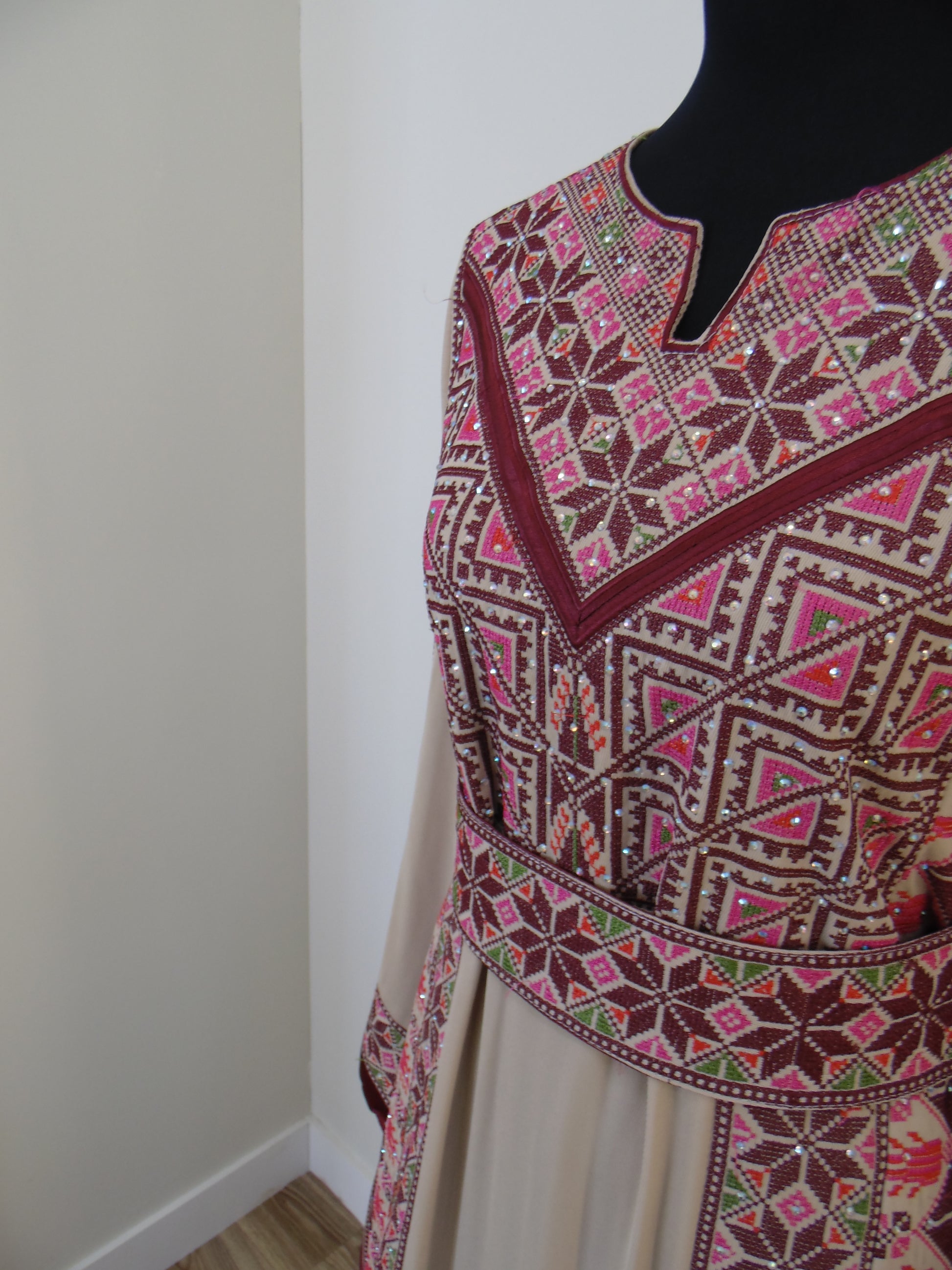 Traditional embroidered fabric with intricate patterns on a white surface