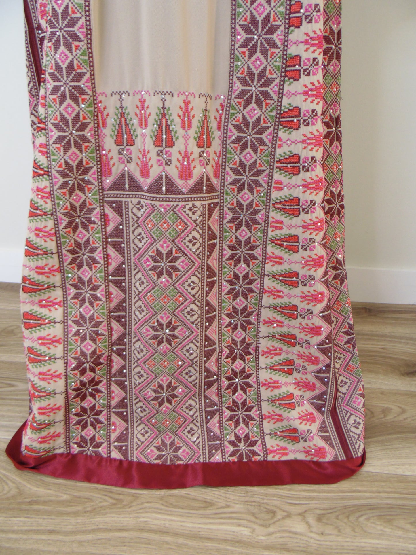 Traditional embroidered fabric with intricate patterns on a wooden surface