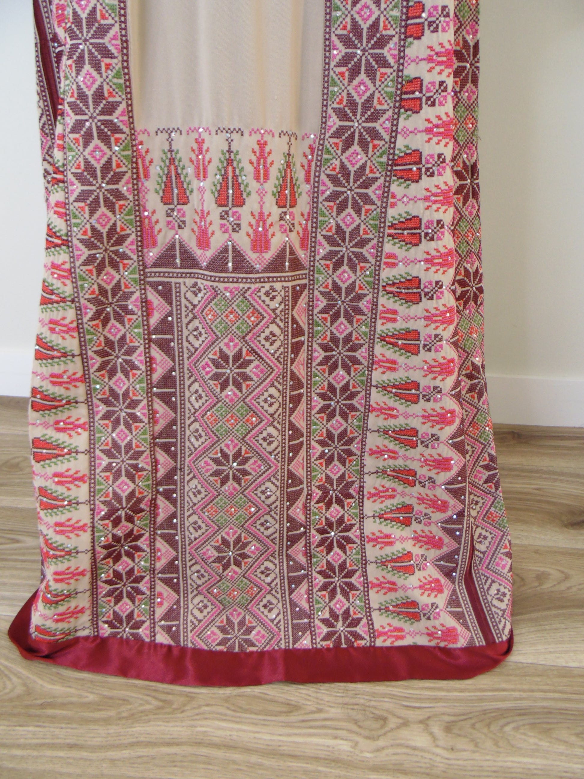 Traditional embroidered fabric with intricate patterns on a wooden surface