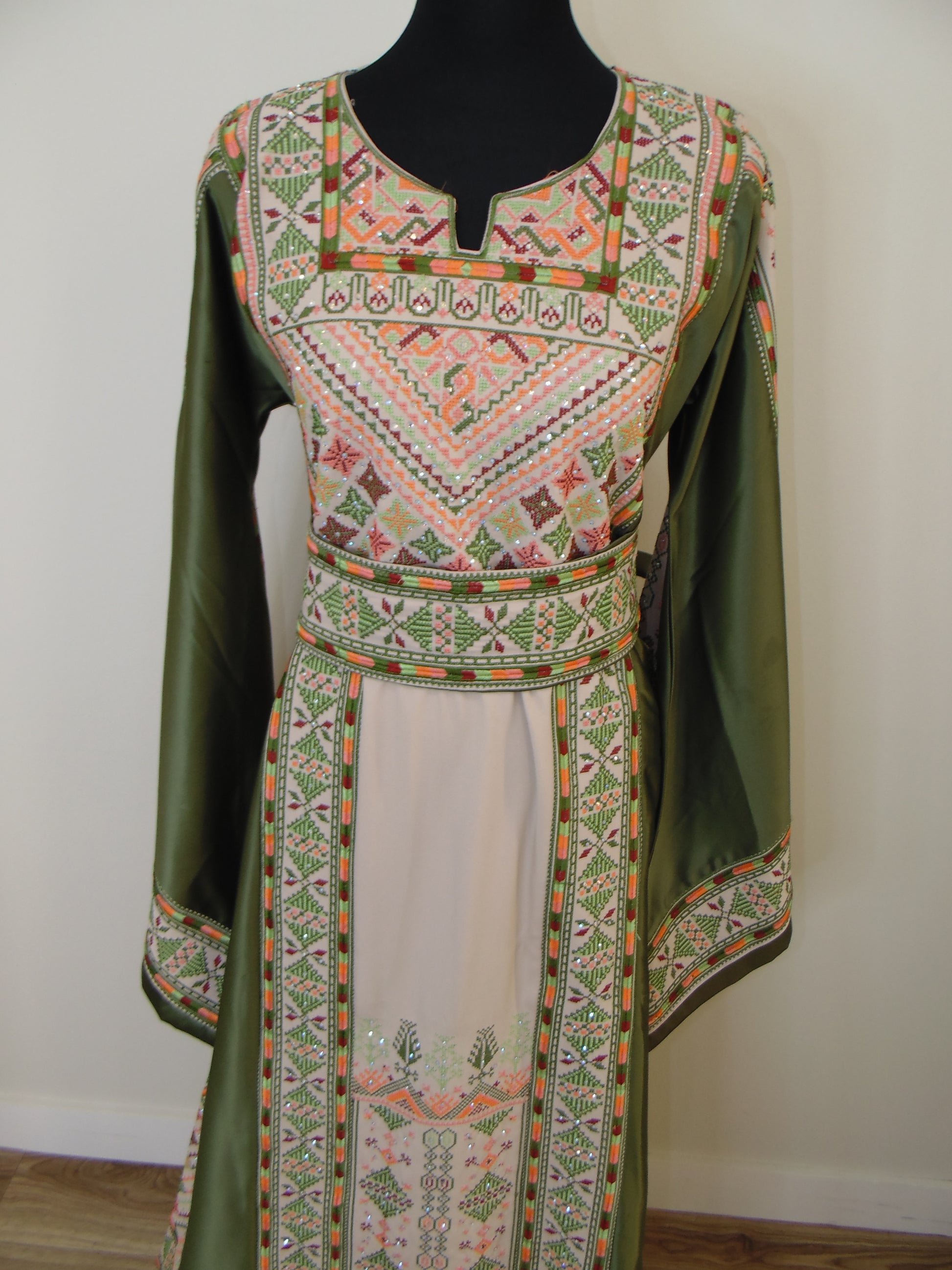 Green and patterned fabric on a mannequin with a white background