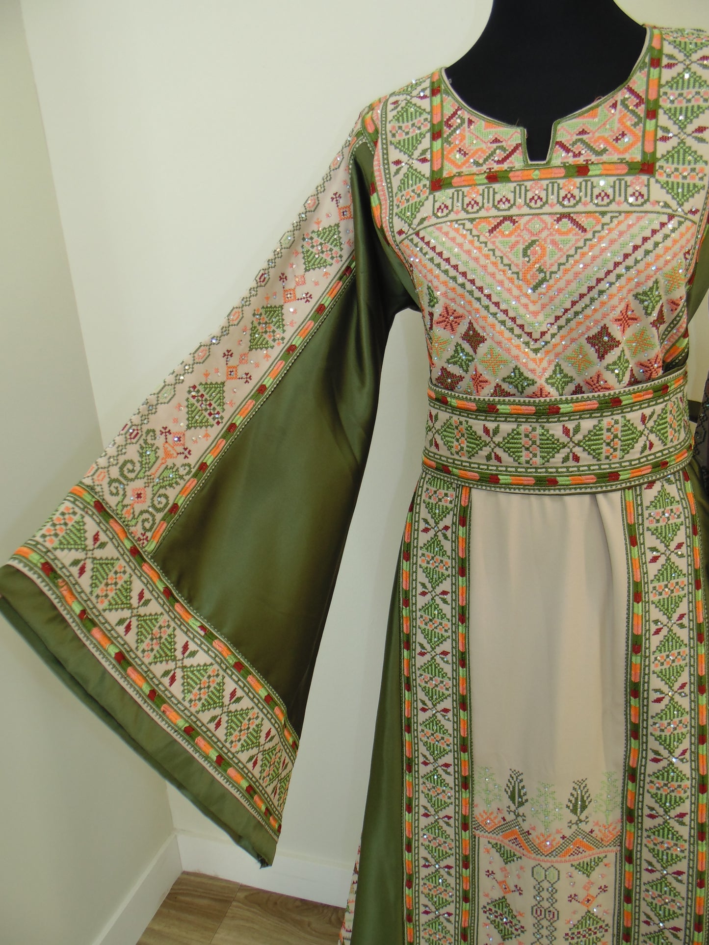 Traditional embroidered garment with geometric patterns on a white background