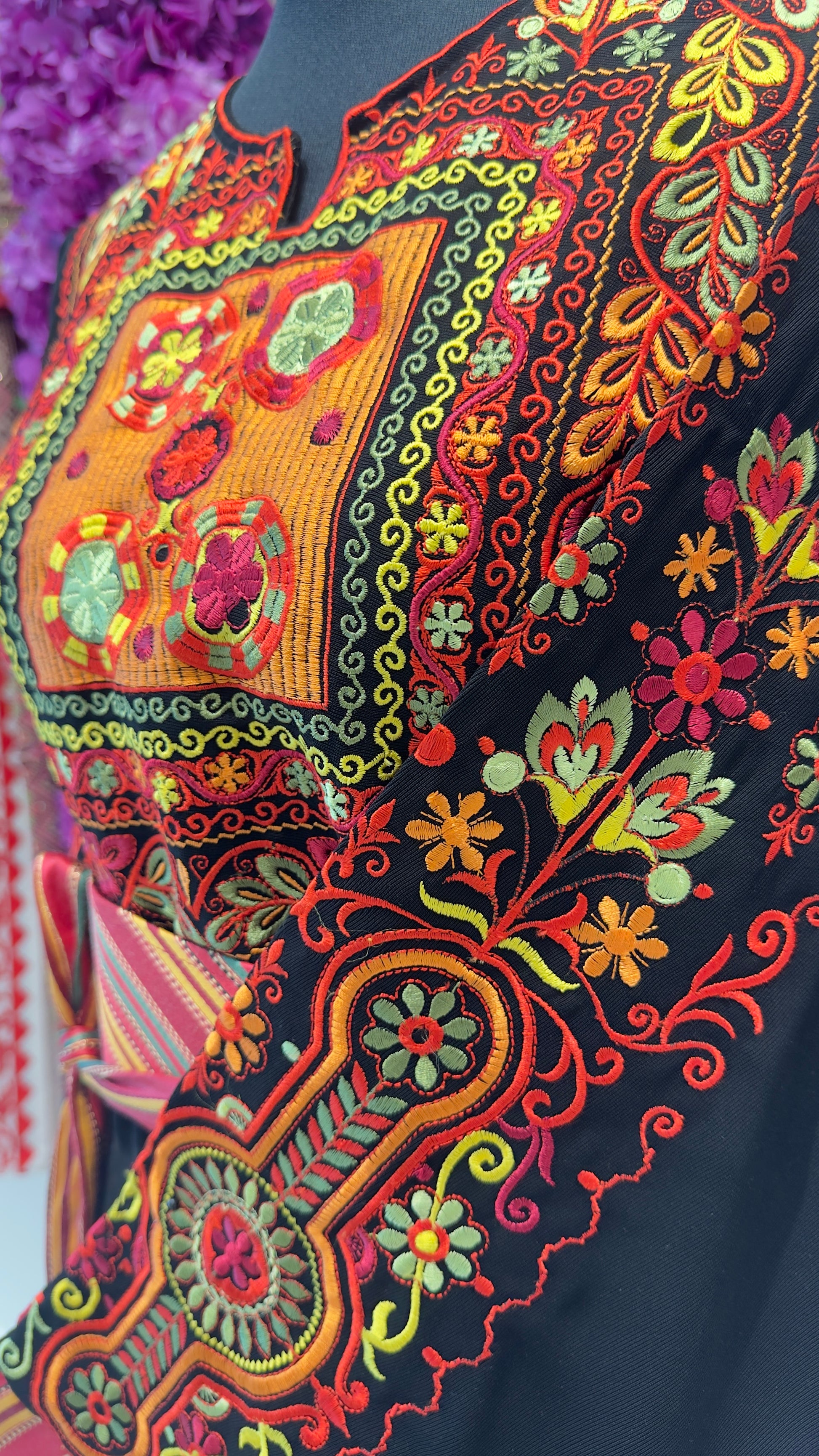 Close-up of a colorful embroidered garment with intricate patterns.