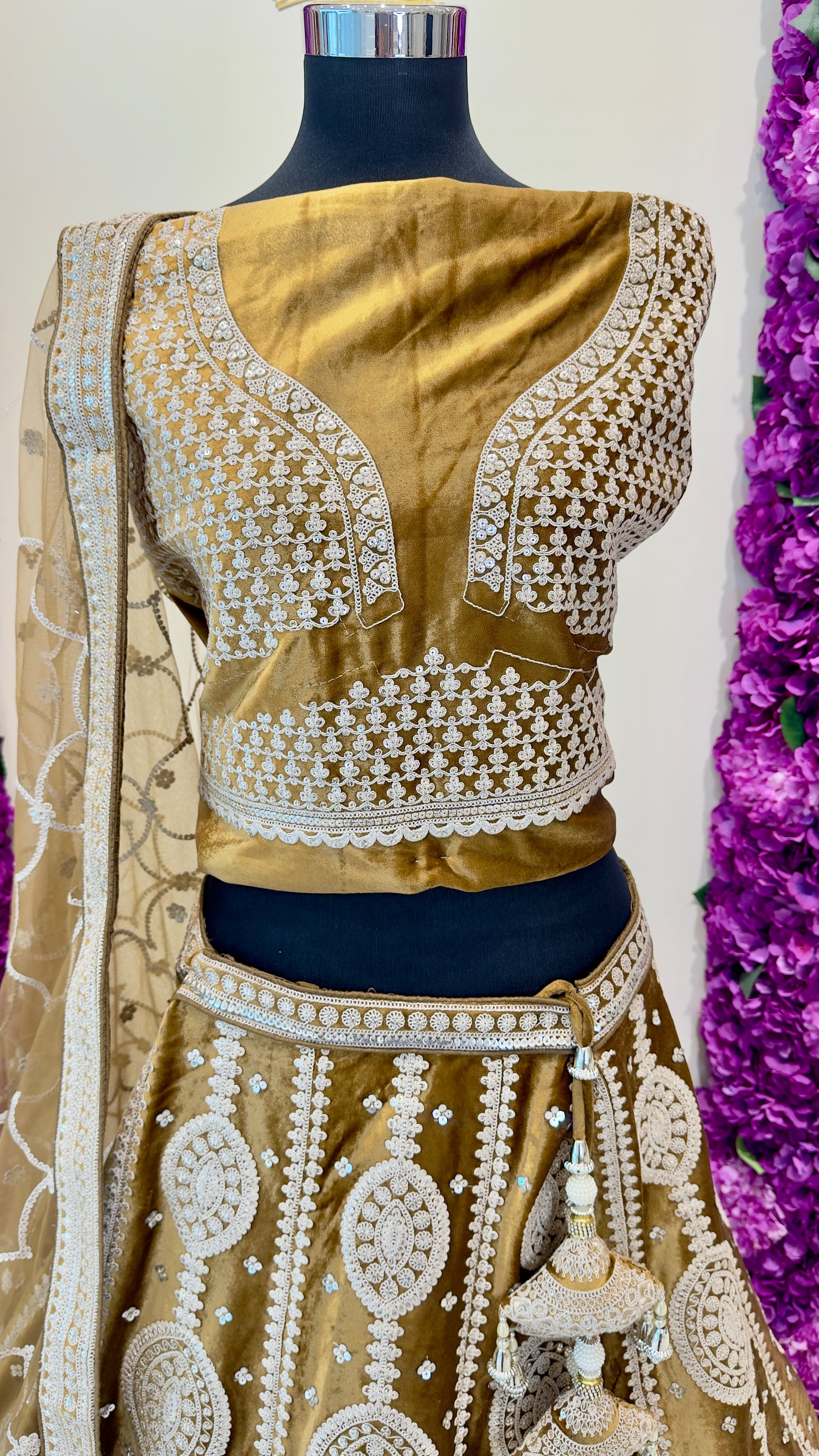 Gold embroidered blouse on a mannequin with a white background