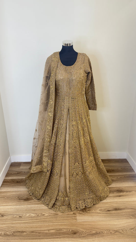 Long embroidered dress on a mannequin against a white wall.