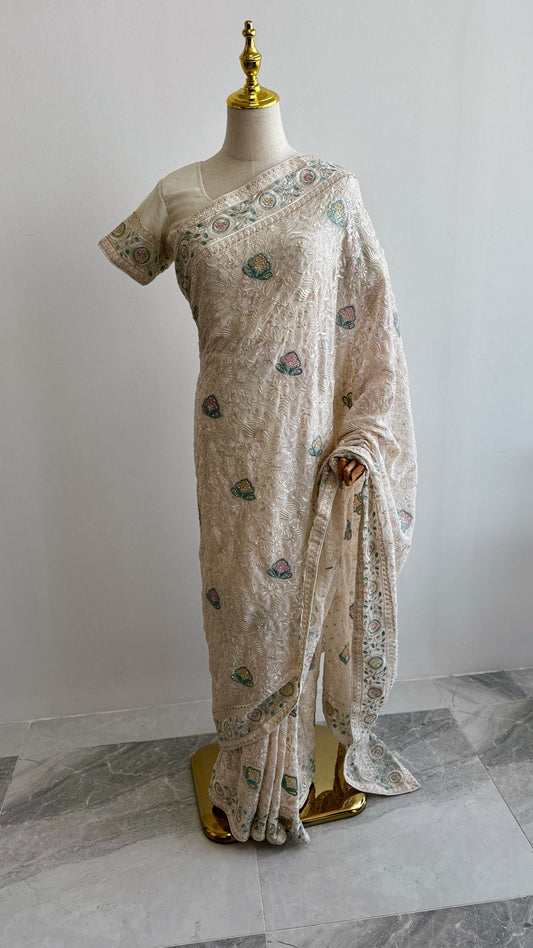 Off white Chikankari saree with floral embroidery displayed on mannequin