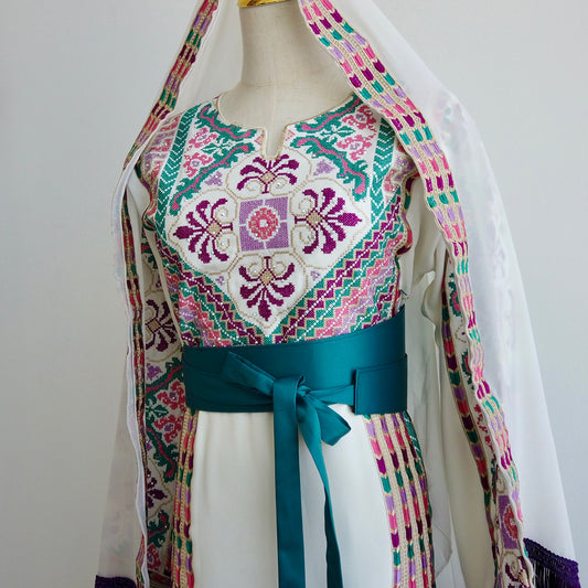 Front view of Palestinian thobe with purple, green, and pink embroidery and teal belt - displayed on a mannequin