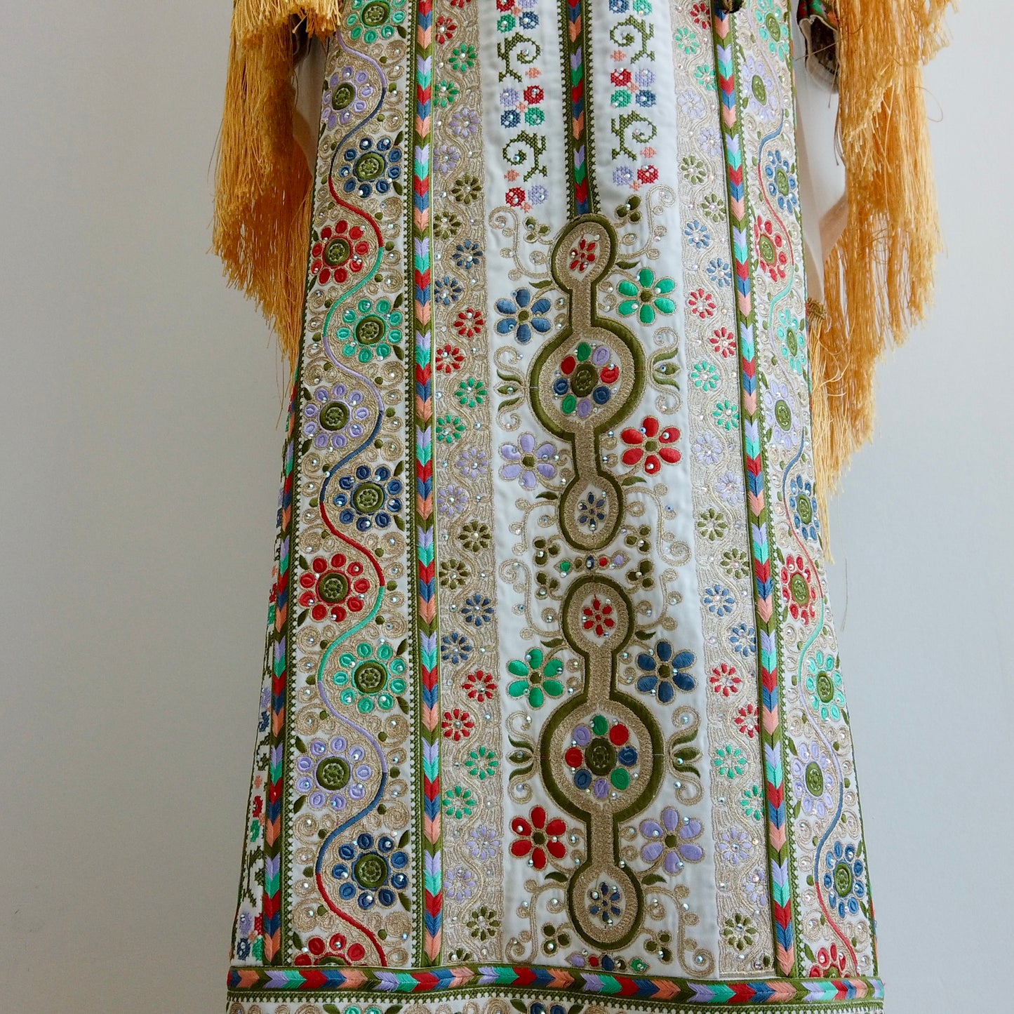 Close-up of floral embroidery patterns and fringe-detailed wide sleeves highlighting artisanal precision