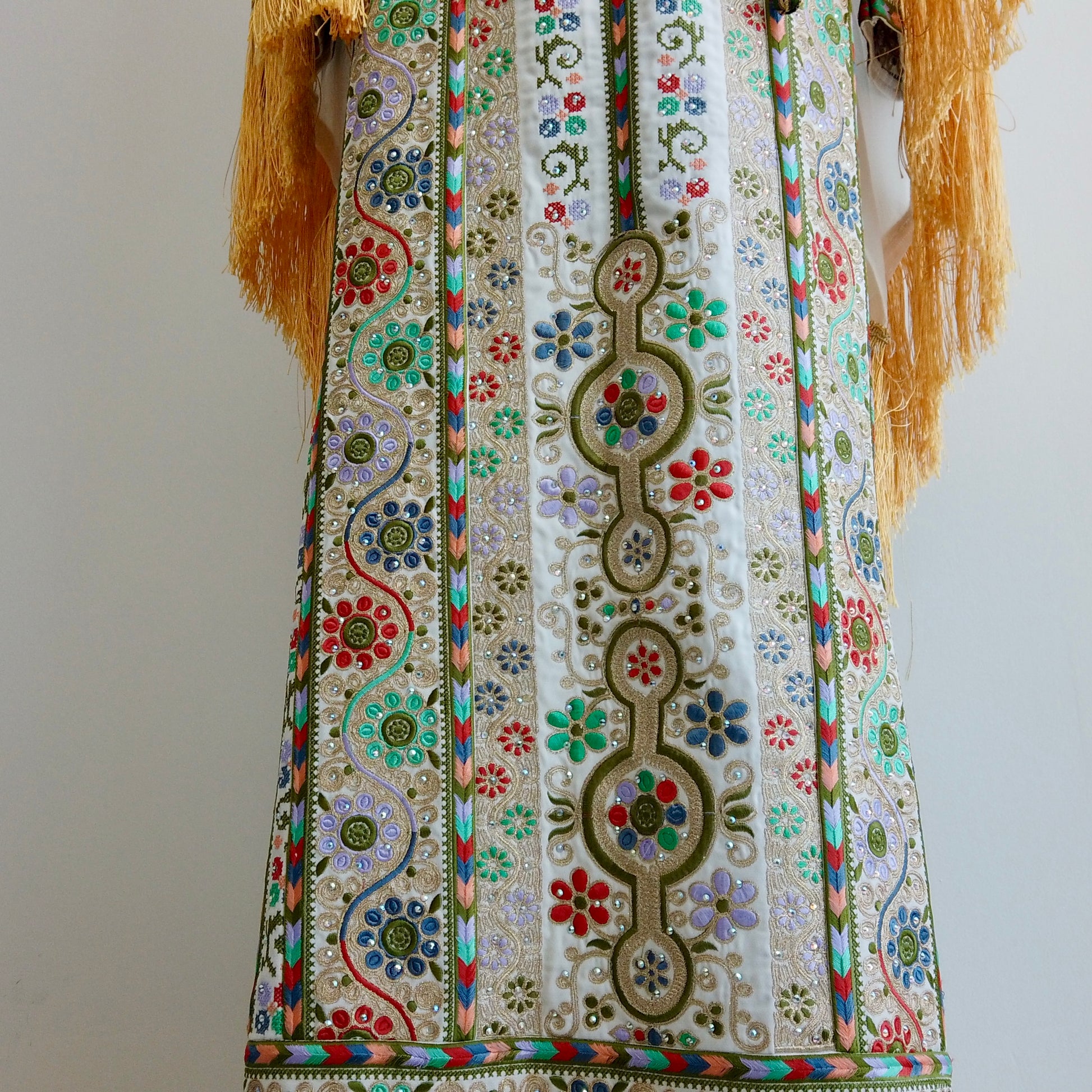 Close-up of floral embroidery patterns and fringe-detailed wide sleeves highlighting artisanal precision