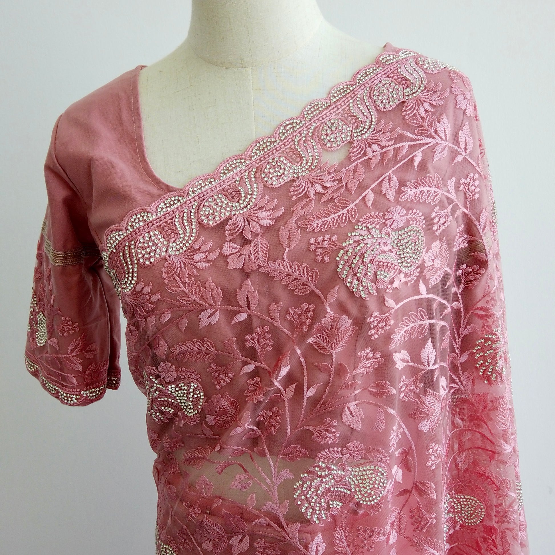 Pink net ready-to-wear saree with silver floral embroidery displayed on a mannequin