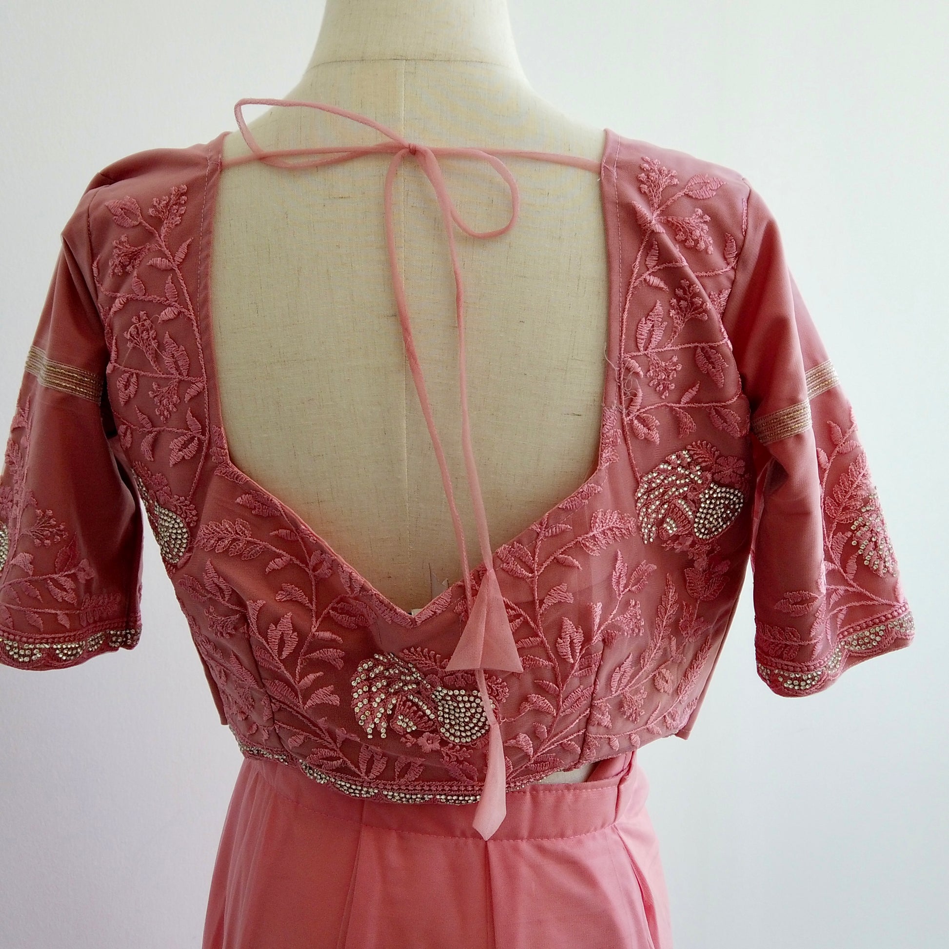 Pink embroidered ready to wear Saree blouse on a mannequin with a white background