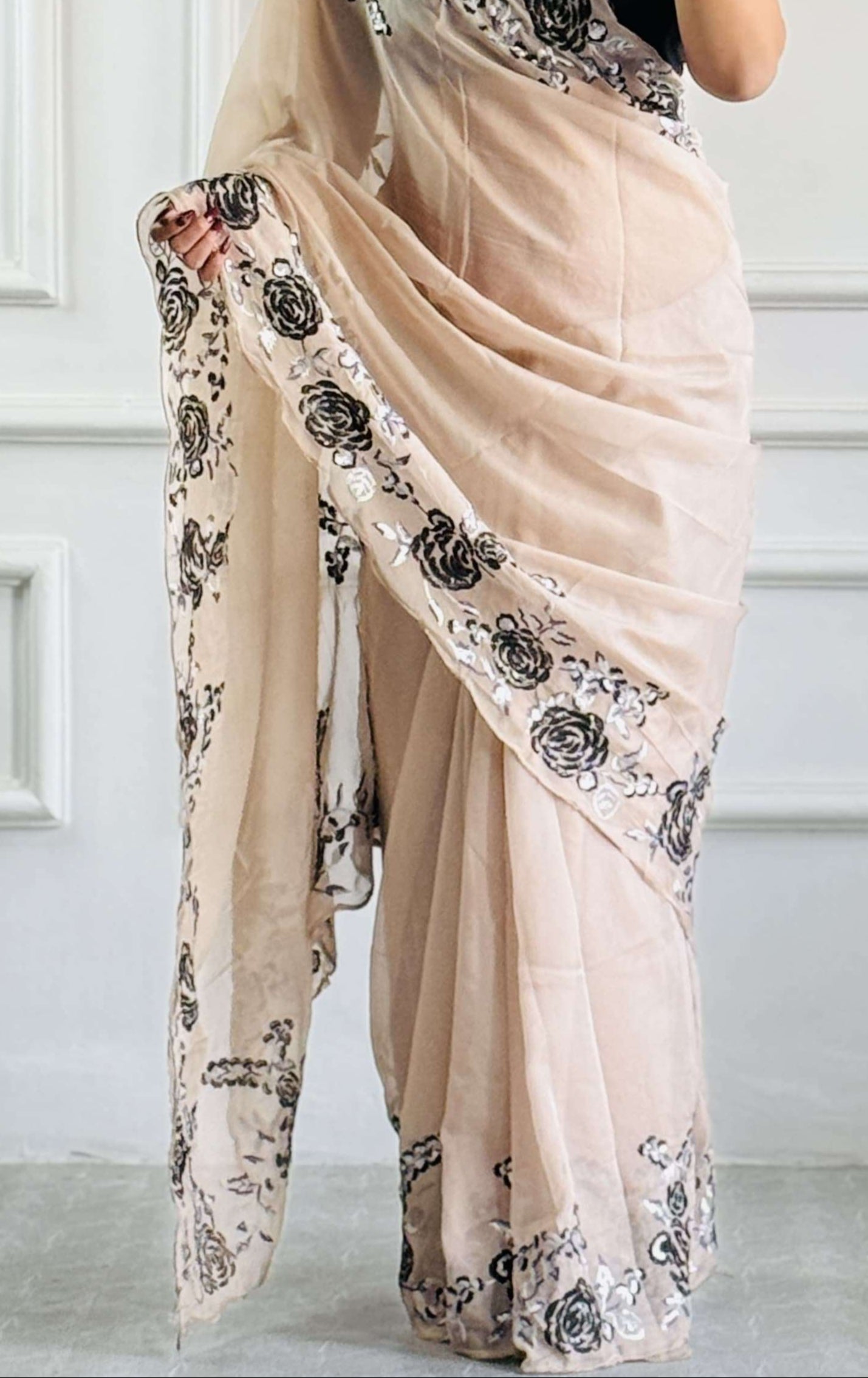 Close-up of black floral embroidery on sheer organza silk fabric.