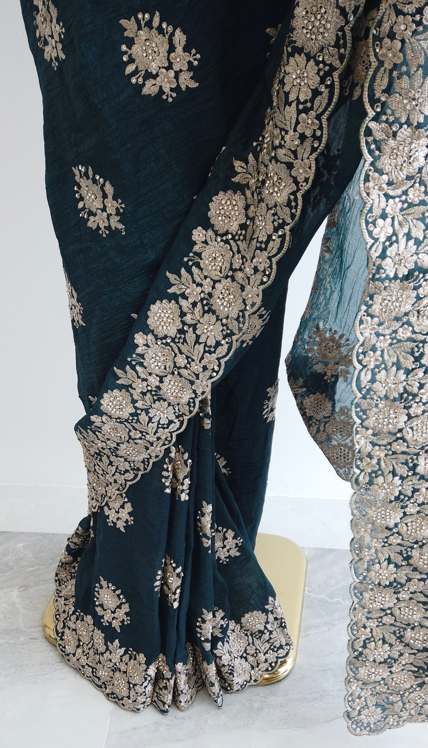 Full view of the teal green saree showcasing detailed border and pre-stitched pleats