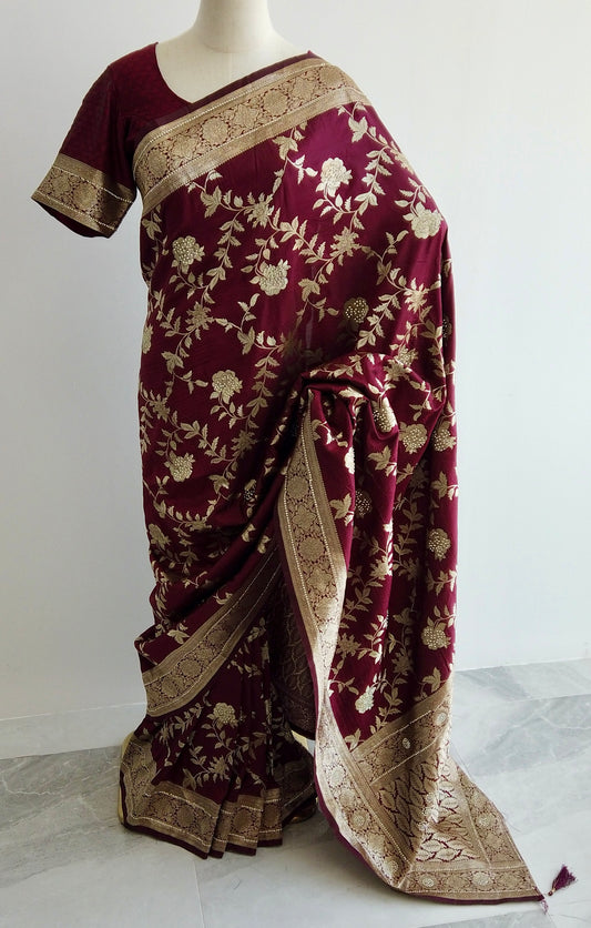 Maroon Banarasi silk ready-to-wear saree with gold floral embroidery and stone embellishments displayed on a mannequin.