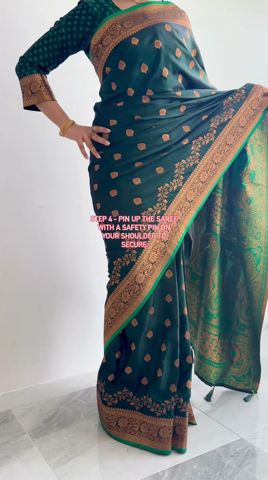 Green satin silk saree with gold border and patterns on a white background