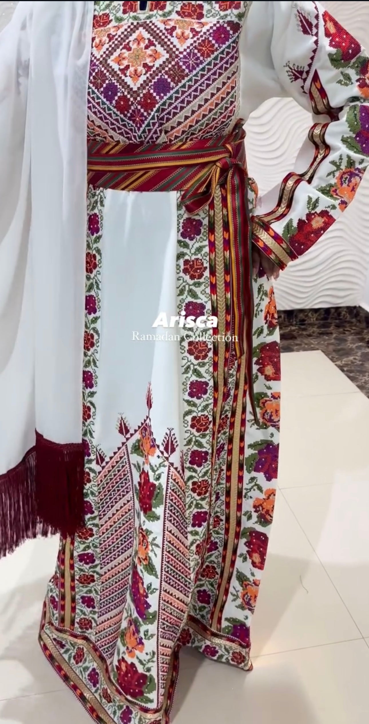 Full-length view of the thobe showcasing floral and geometric patterns with a striped belt