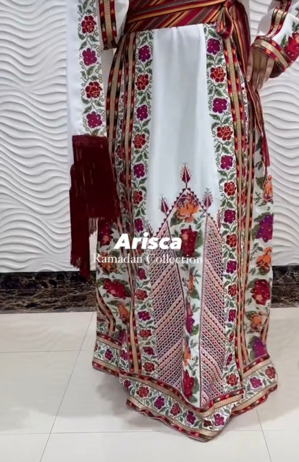 Close-up of intricate red and green embroidery on the chest of Arisca’s Palestinian thobe.