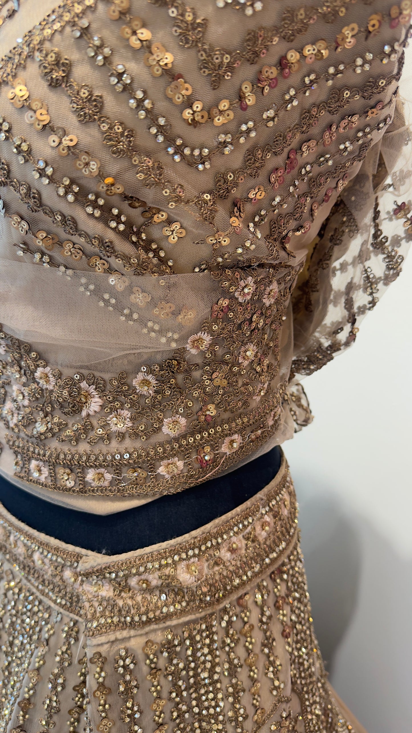 Close-up of a beaded garment with intricate patterns on a plain background