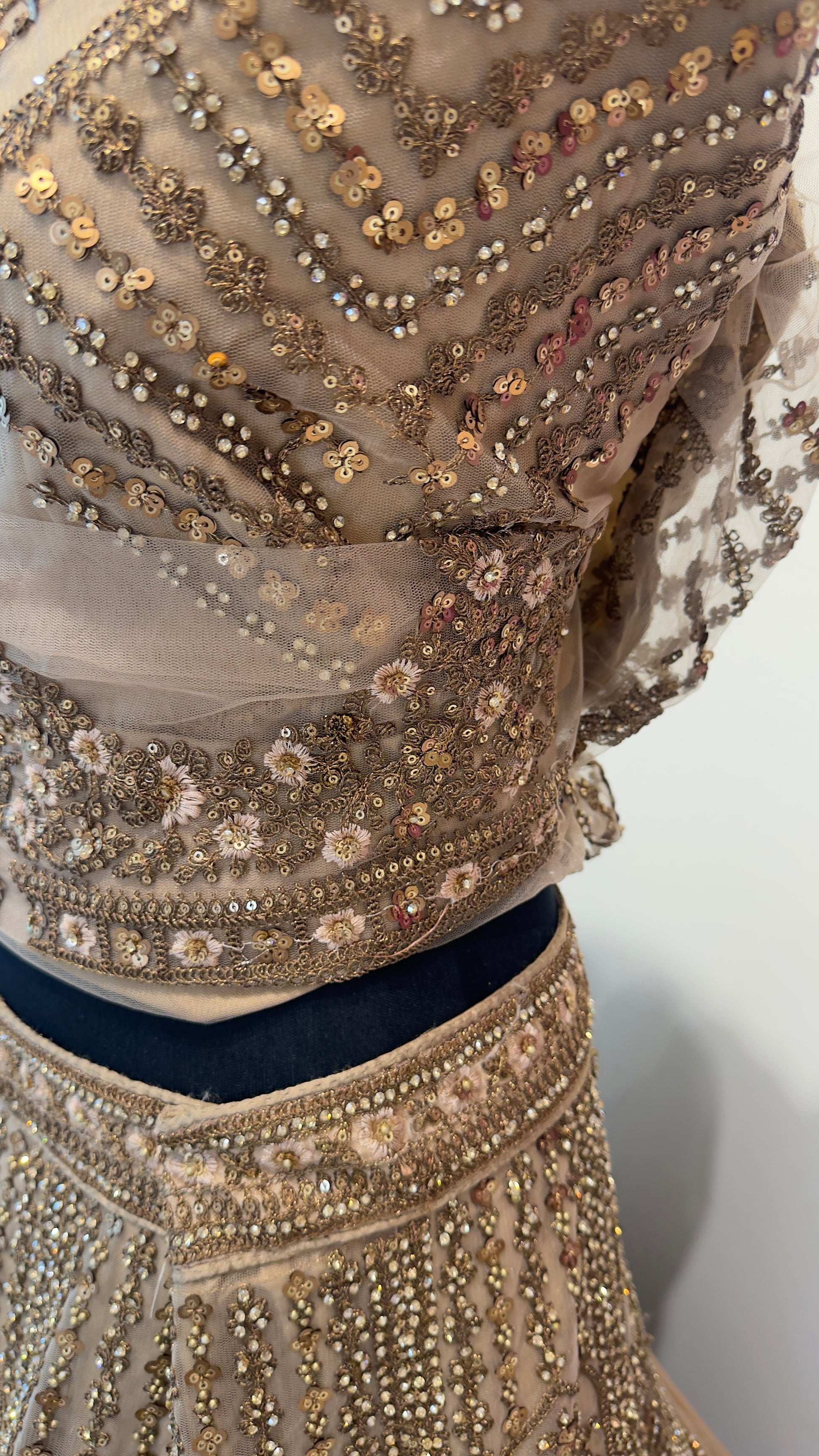 Close-up of a beaded garment with intricate patterns on a plain background