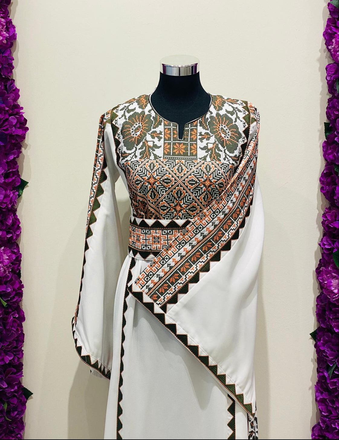 Ivory Palestinian-inspired thobe with geometric and floral embroidery at Arisca Qatar.