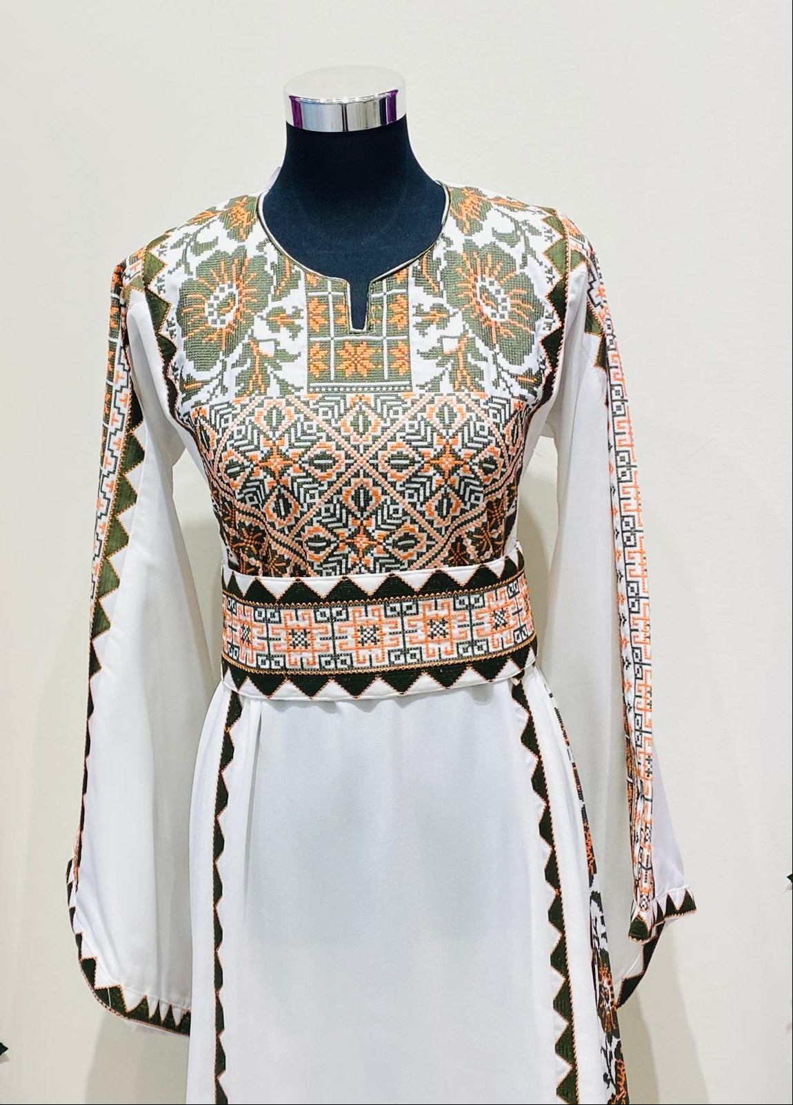Ivory Palestinian-inspired thobe with geometric and floral embroidery at Arisca Qatar.