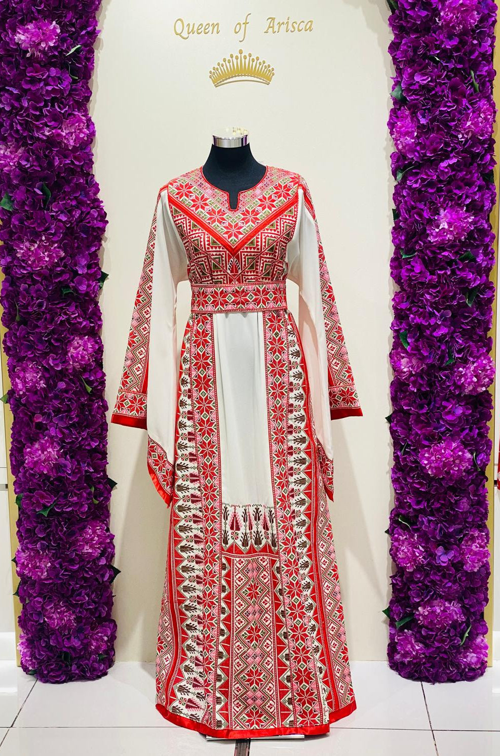Luxury ivory Palestinian thobe at Arisca, detailed with red geometric embroidery.