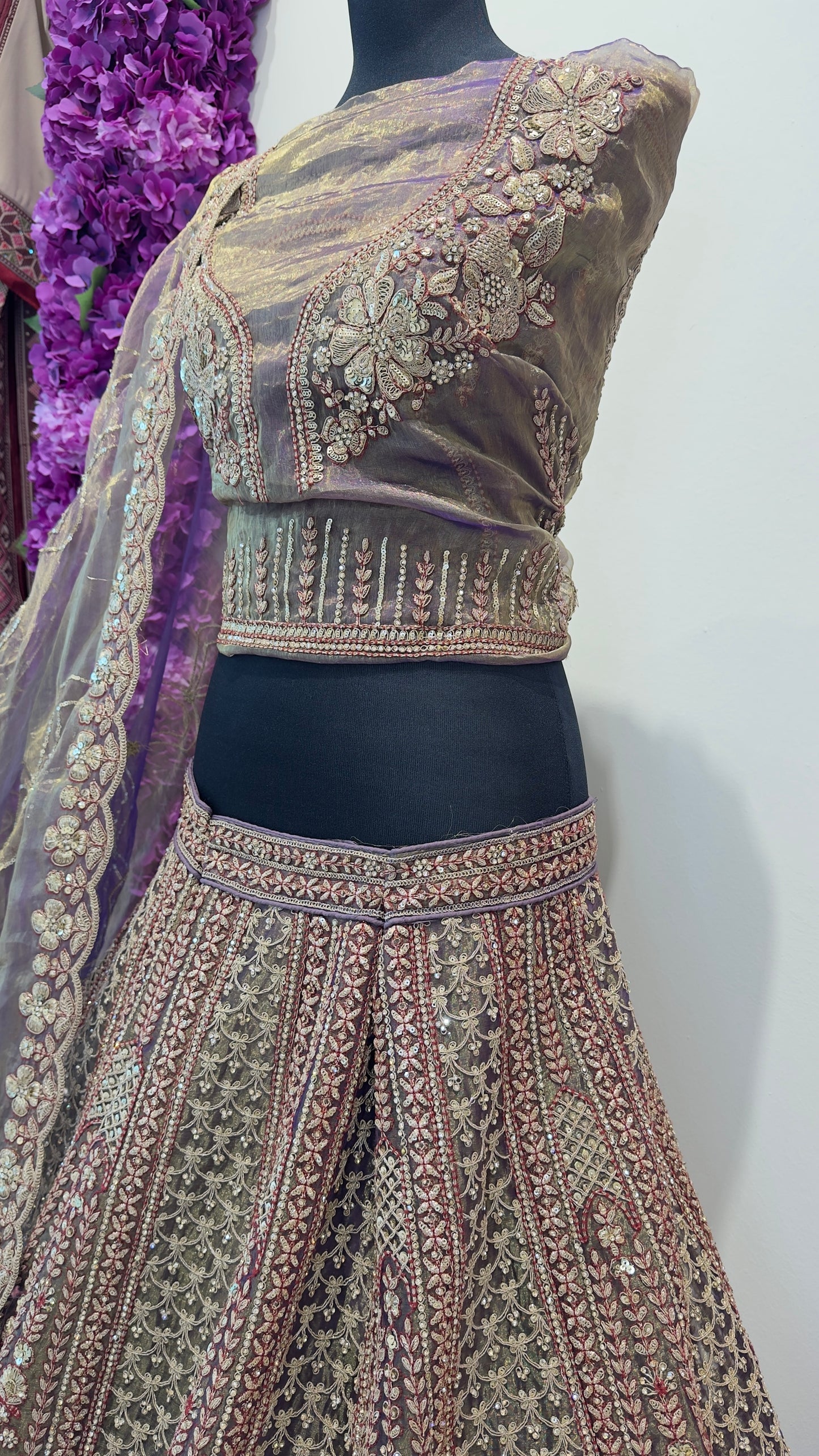 Traditional embroidered lehenga with a matching blouse on a mannequin against a white background.