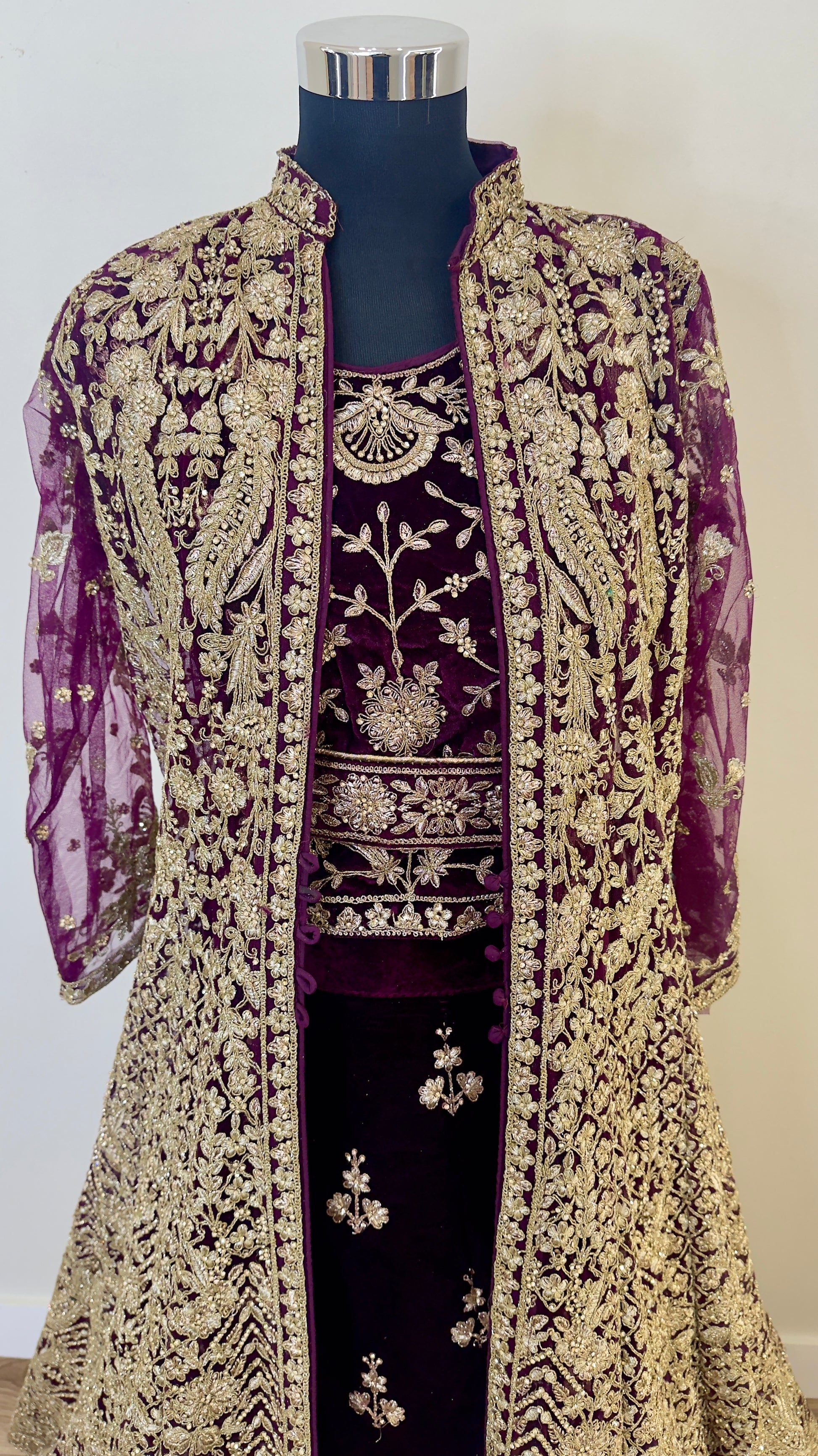 Embroidered purple and gold outfit on a mannequin against a white background