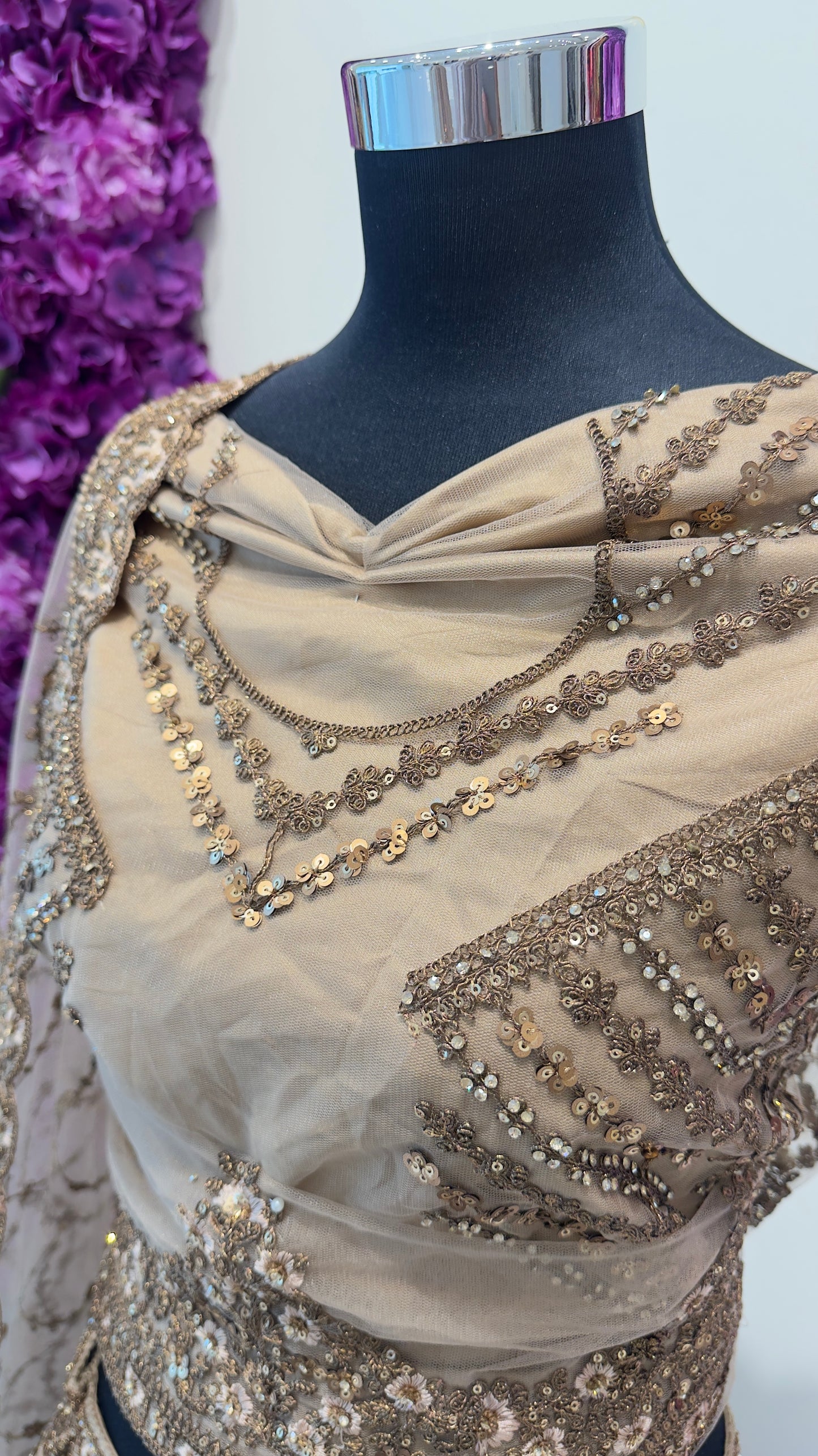 Golden Lehenga with intricate gold embroidery on a mannequin against a white background