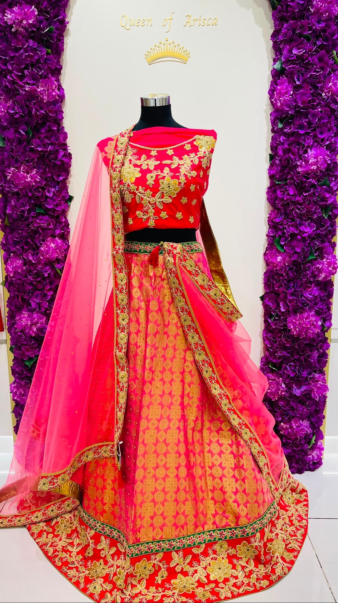 A red and pink lehenga  with gold embroidery.