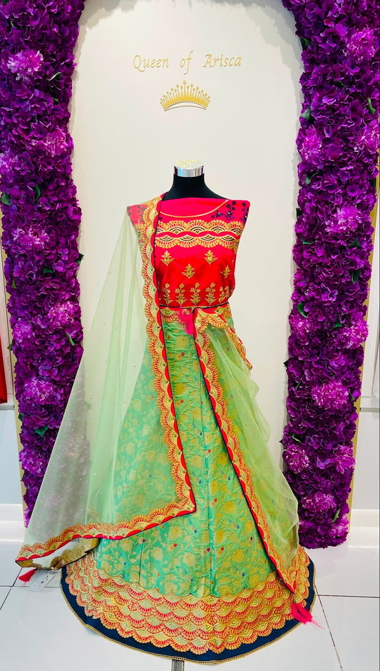 A traditional Indian lehenga dress 
The outfit features a bright pink sleeveless bodice with gold embroidery, a light green flared skirt with gold and orange border detailing, and a matching sheer light green dupatta.