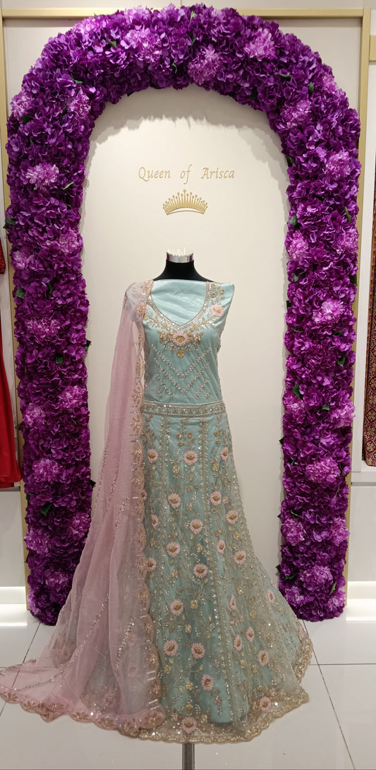 A refreshing mint green lehenga with blush pink floral embroidery and gold accents