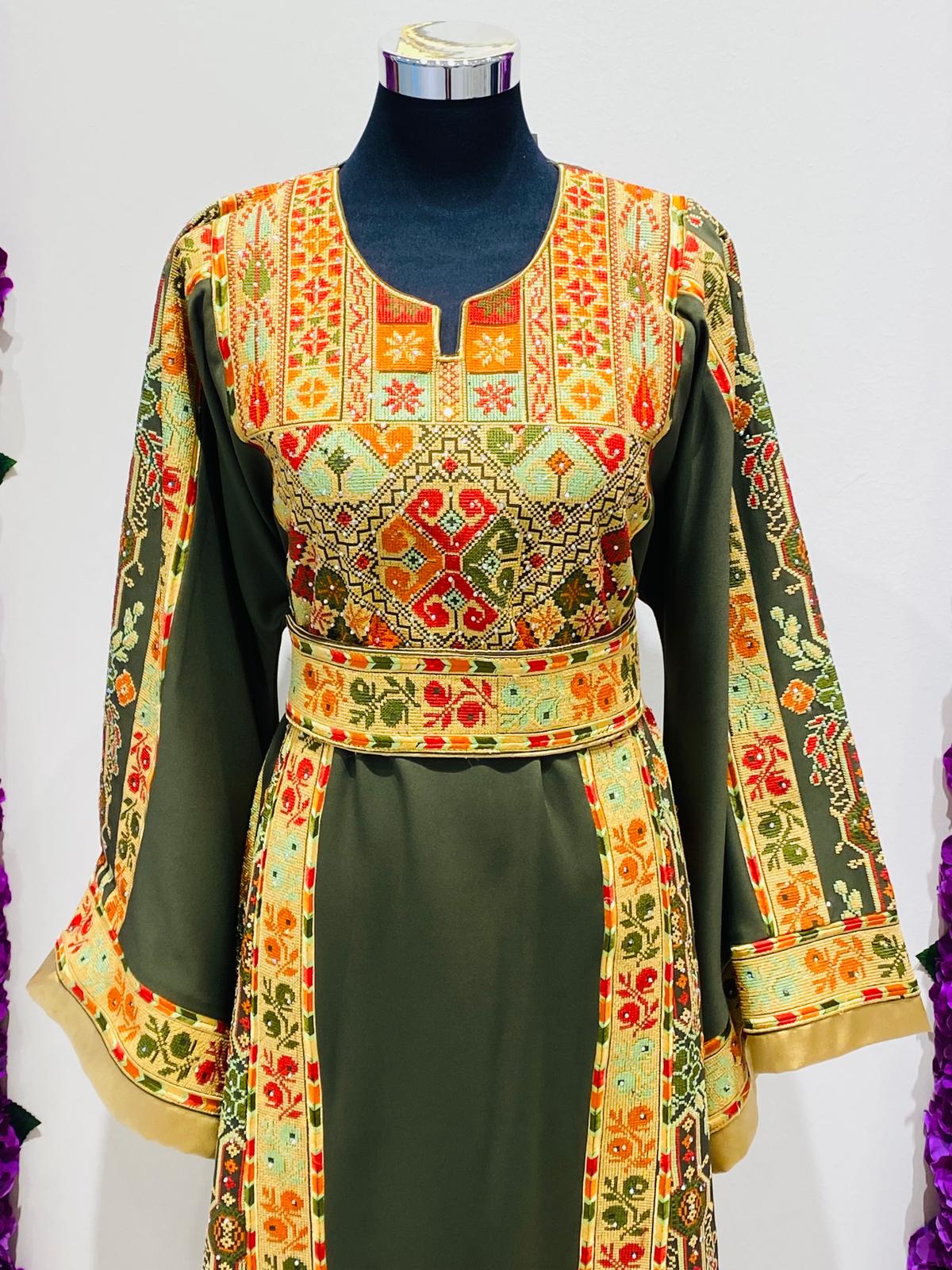 Olive green Palestinian-inspired thobe with colourful geometric embroidery at Arisca Qatar.