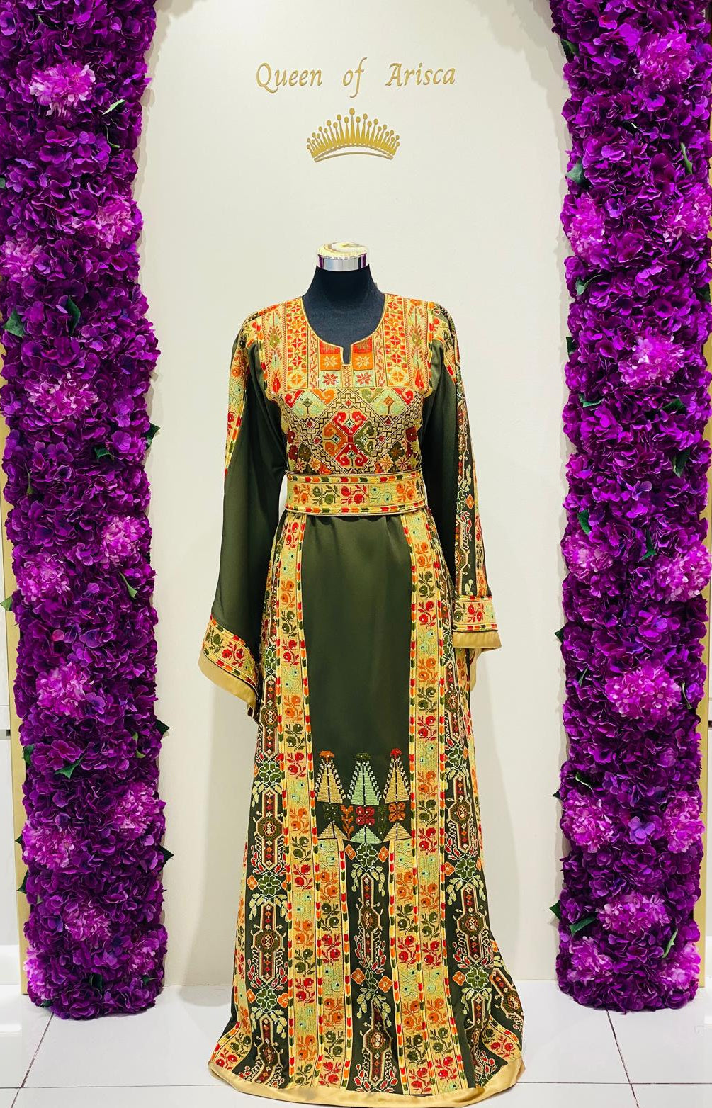 Olive green Palestinian-inspired thobe with colourful geometric embroidery at Arisca Qatar.