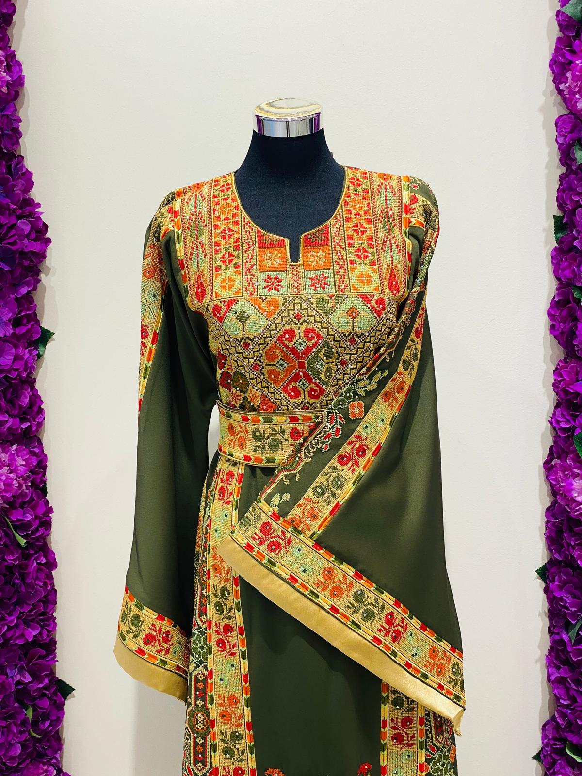 Olive green Palestinian-inspired thobe with colourful geometric embroidery at Arisca Qatar.