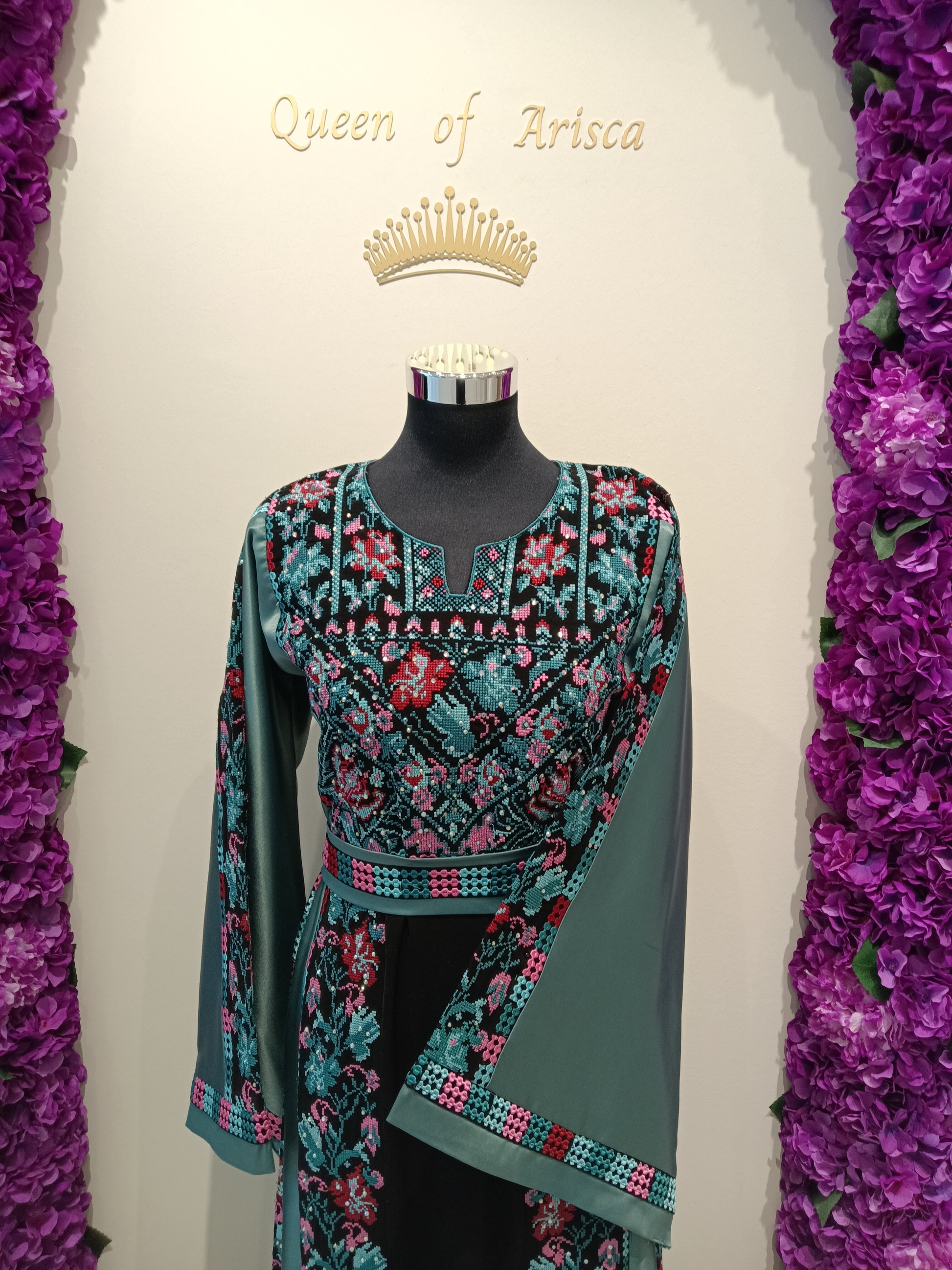 Palestinian thobe, trich deep black, beautifully contrasted with intricate traditional embroidery in teal, turquoise, blush pink, and subtle red tones | Qatar