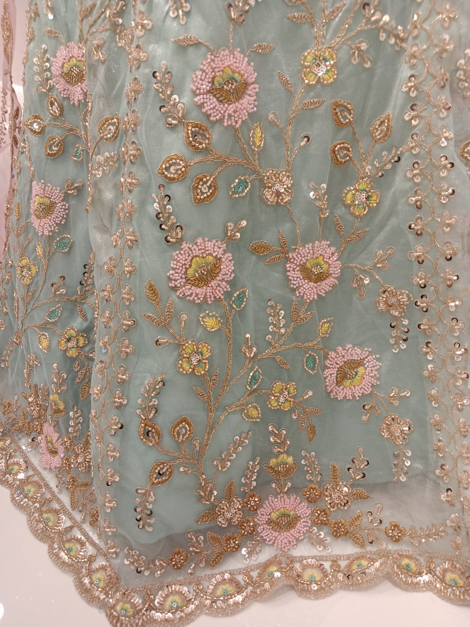 Lehenga Skirt: Net with pastel floral embroidery and sequin highlights.