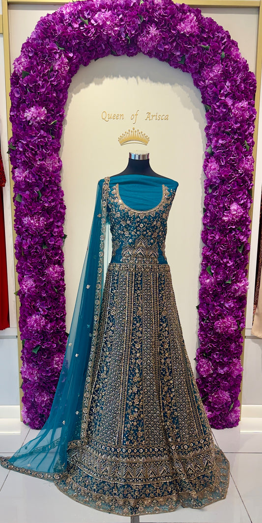 peacock teal lehenga showcases dense antique gold zari and stone embroidery across vertical panels.