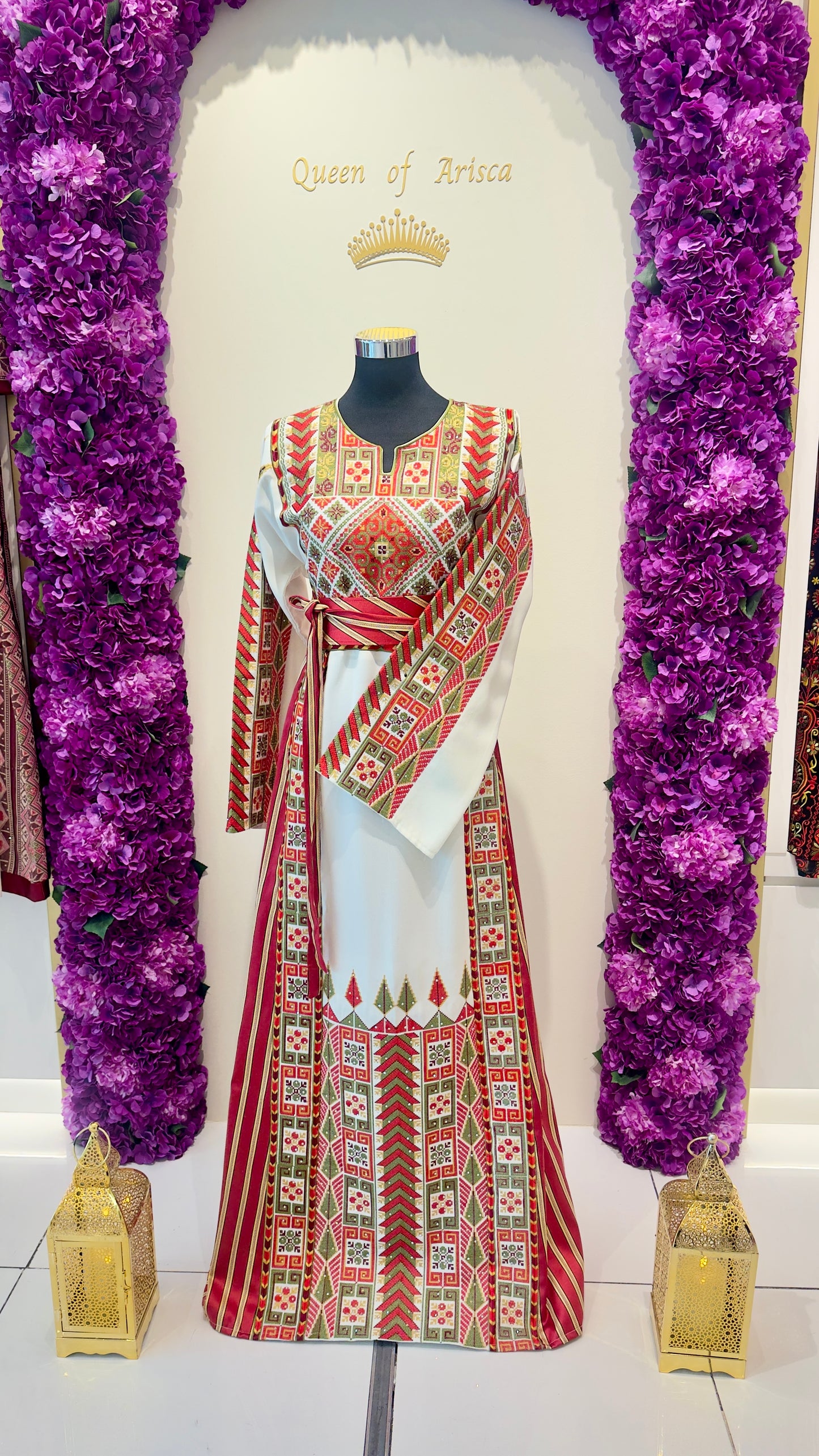 Mannequin wearing a patterned dress with decorative elements on a white background