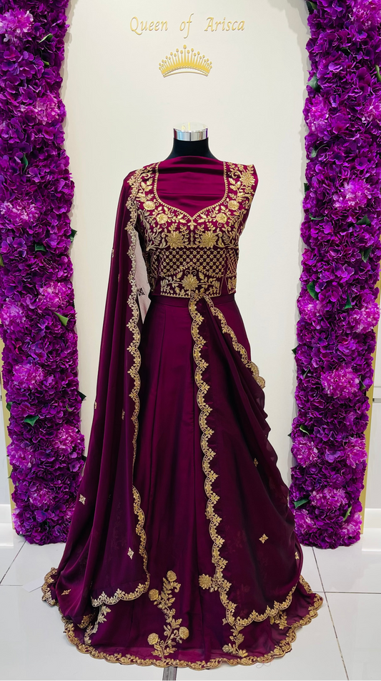 A deep purple velvet party wear lehenga with intricate gold embroidery.