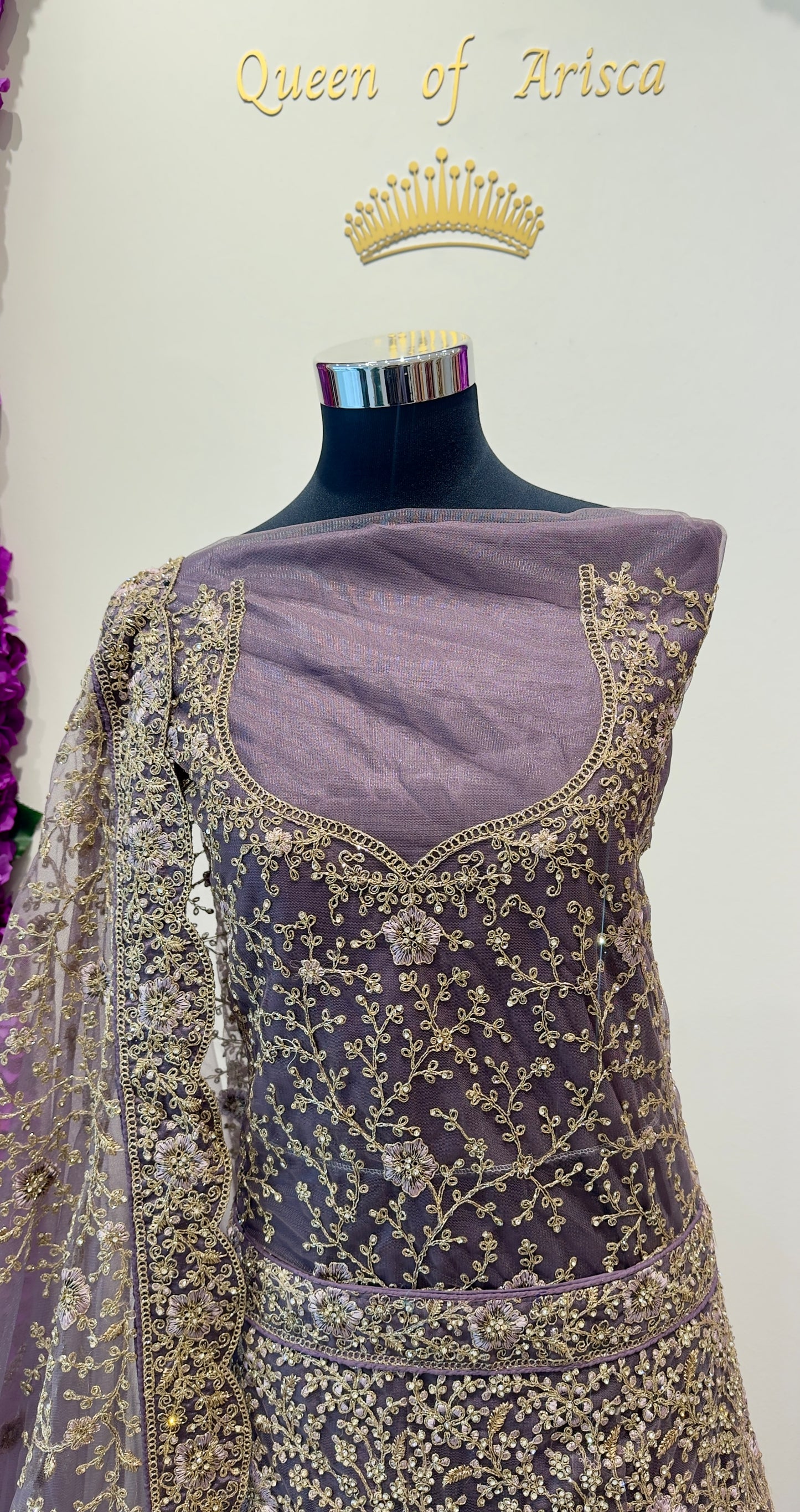 luxurious lehenga features an elegant dusty mauve and soft lavender base adorned with intricate antique gold embroidery throughout the skirt, blouse, and dupatta. 