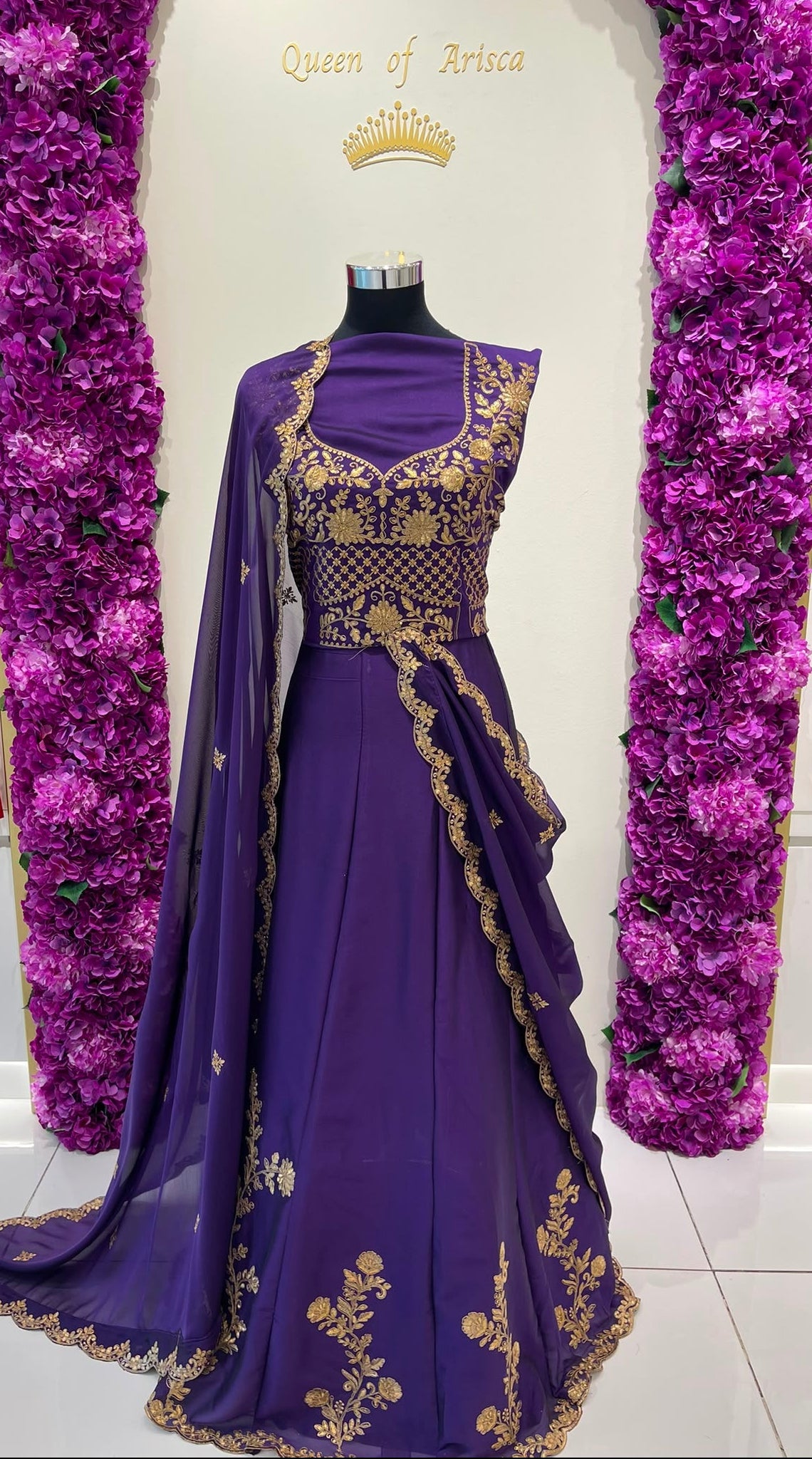 A purple traditional lehenga decorated with gold embroidery and a matching sheer dupatta.  