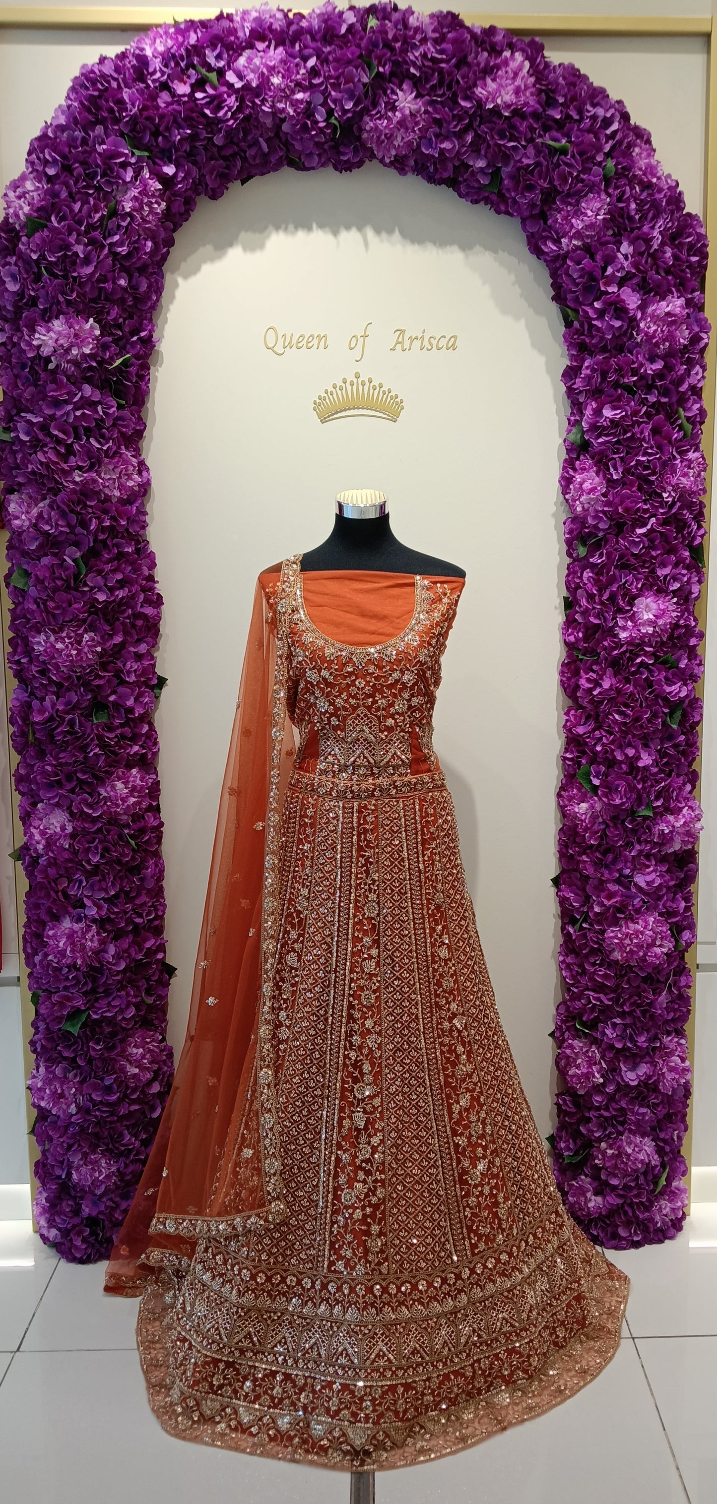 rust orange lehenga features dense silver and antique gold zari embroidery.
